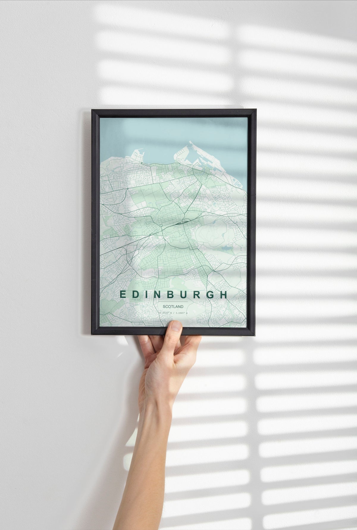 Edinburgh, Scotland, United Kingdom map print in the Forest theme in a black frame held against a pale wall