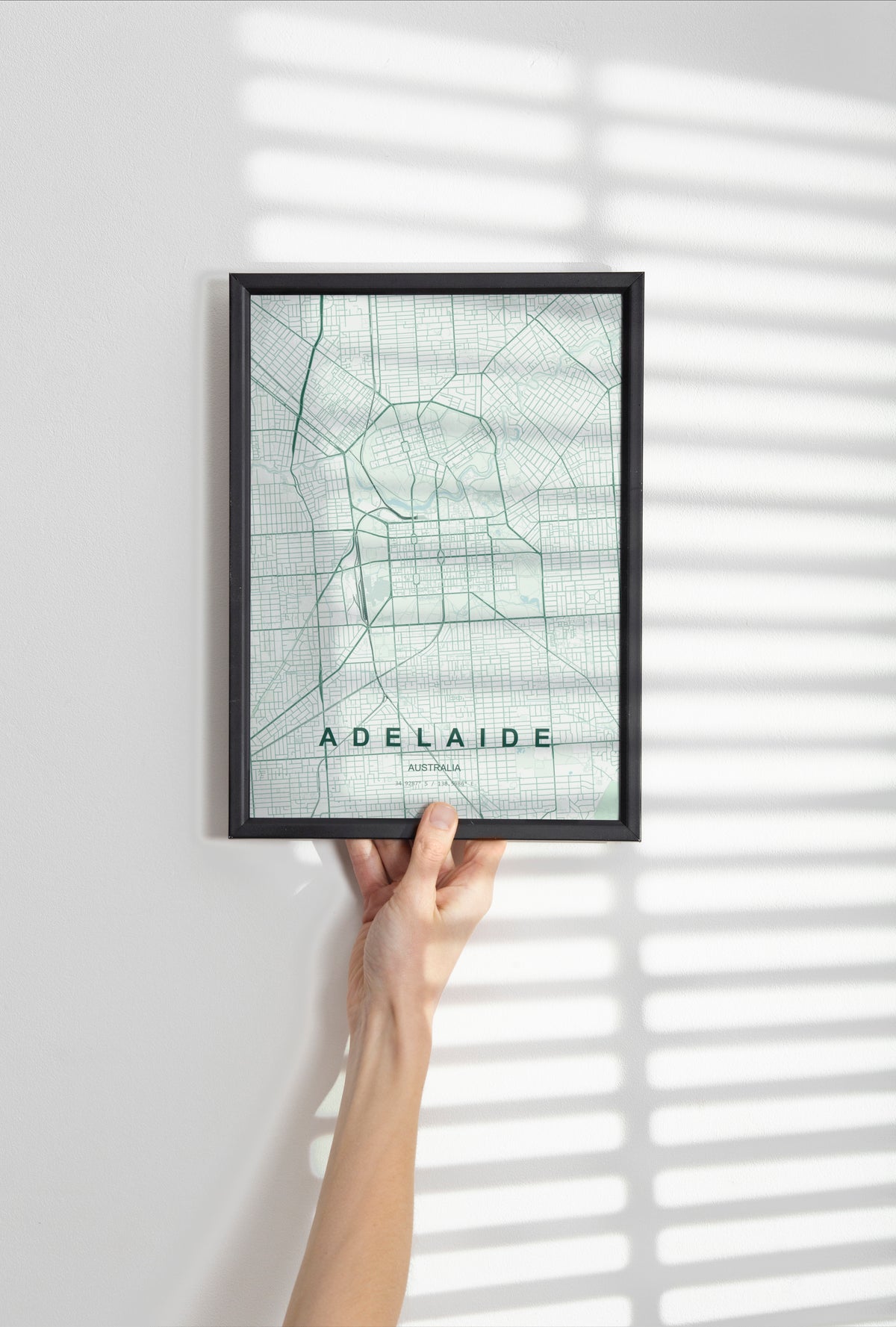 Adelaide, South Australia, Australia map print in the Forest theme in a black frame held against a pale wall