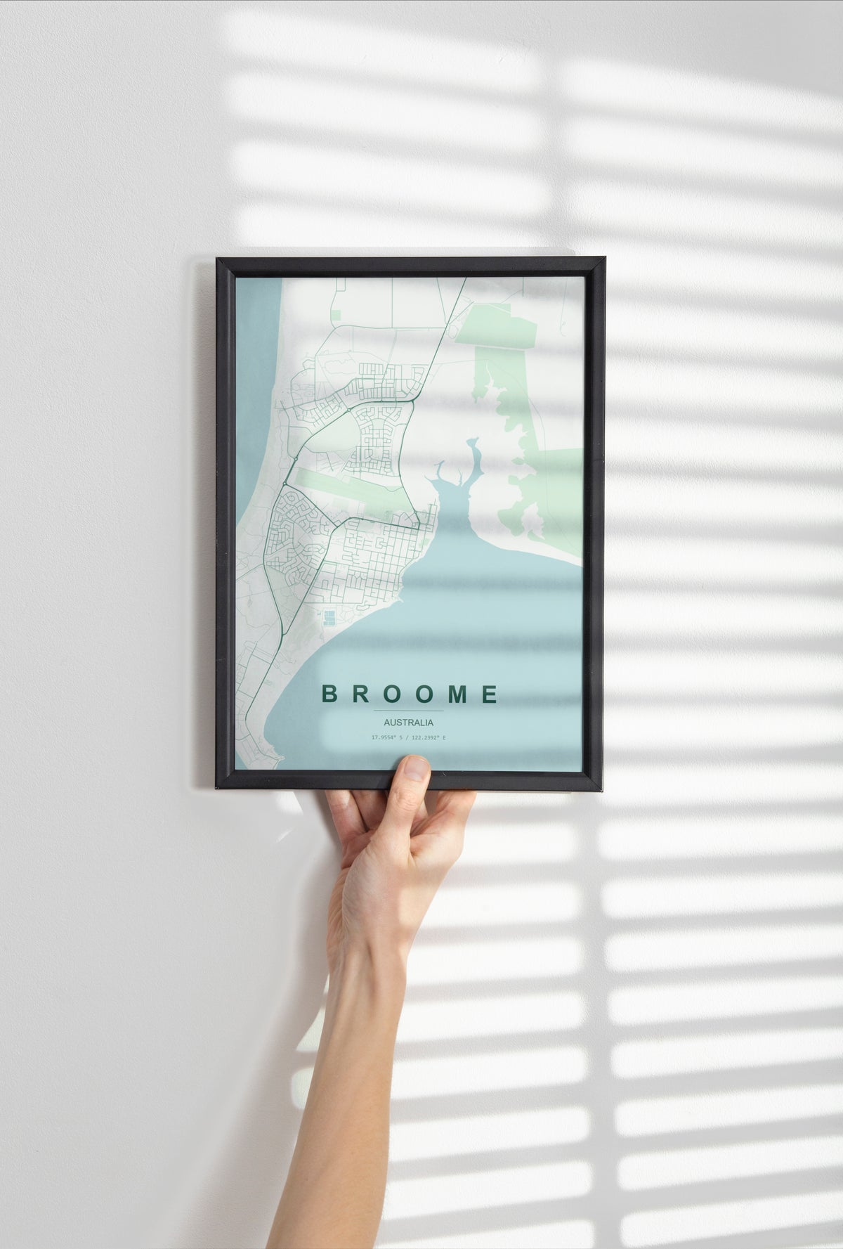 Broome, Western Australia, Australia map print in the Forest theme in a black frame held against a pale wall
