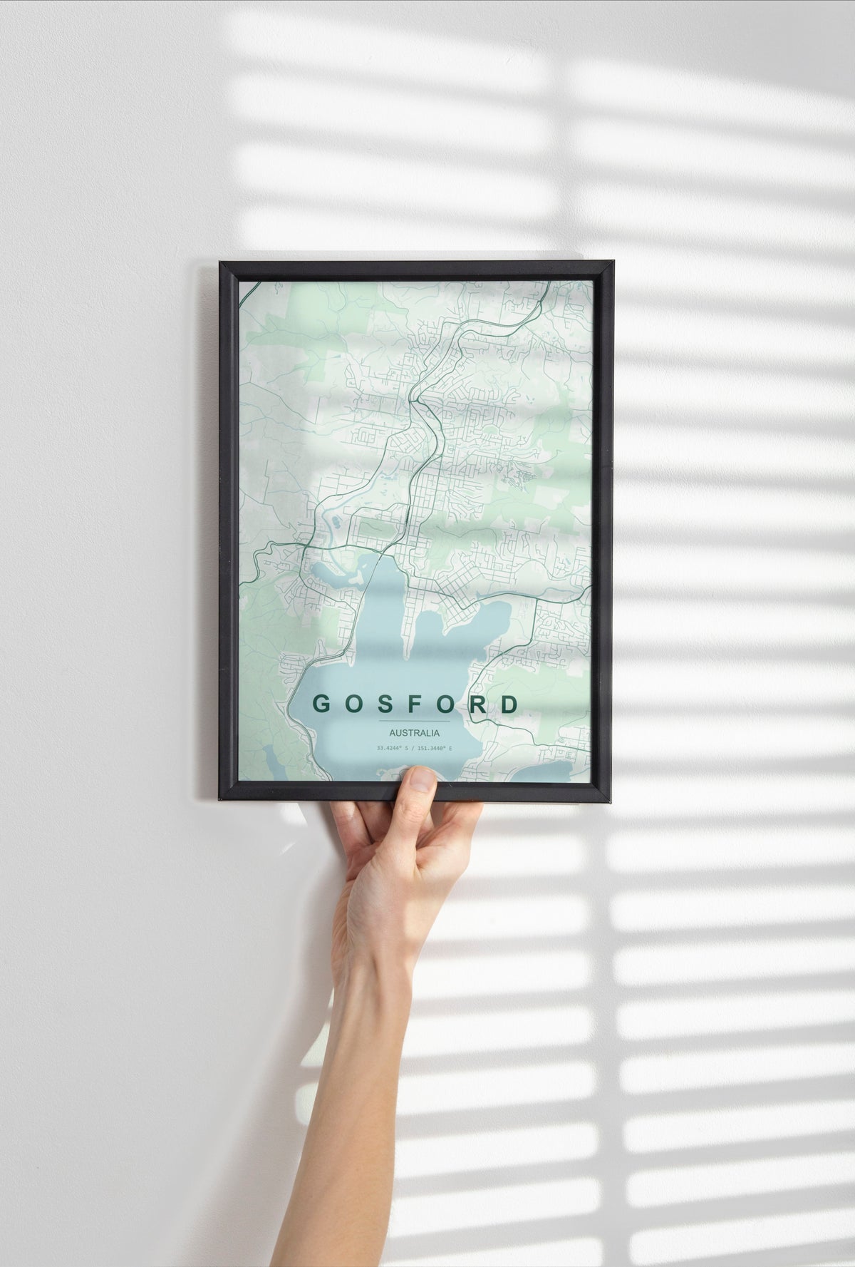 Gosford, New South Wales, Australia map print in the Forest theme in a black frame held against a pale wall