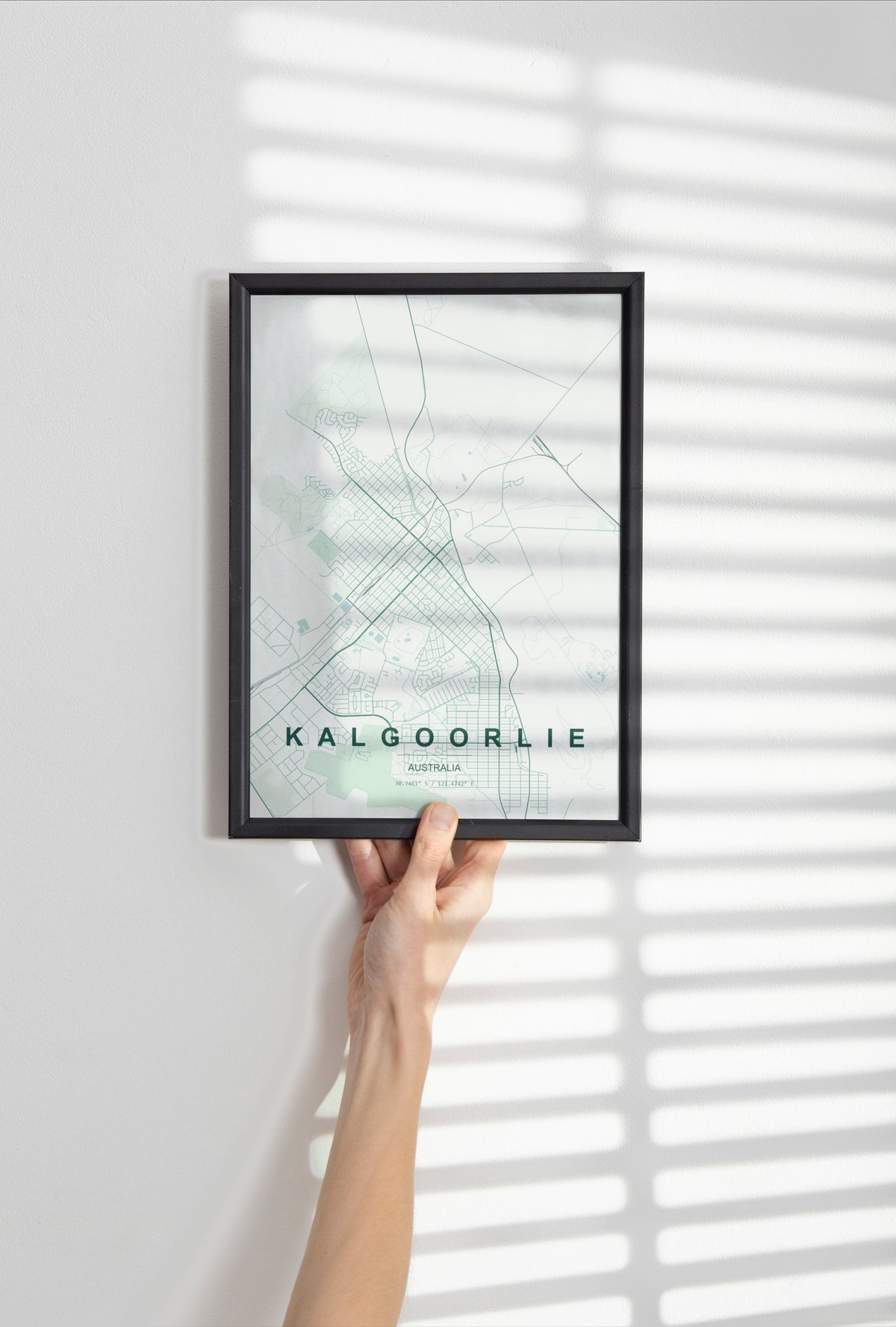 Kalgoorlie, Western Australia, Australia map print in the Forest theme in a black frame held against a pale wall