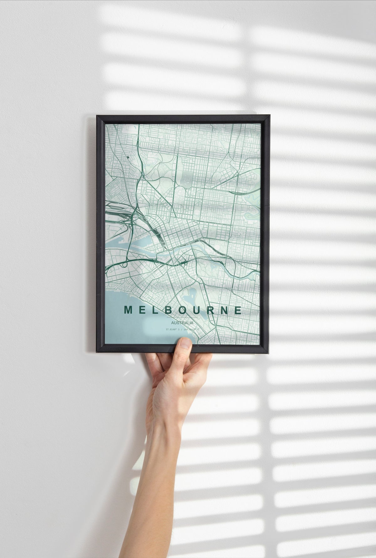 Melbourne, Victoria, Australia map print in the Forest theme in a black frame held against a pale wall