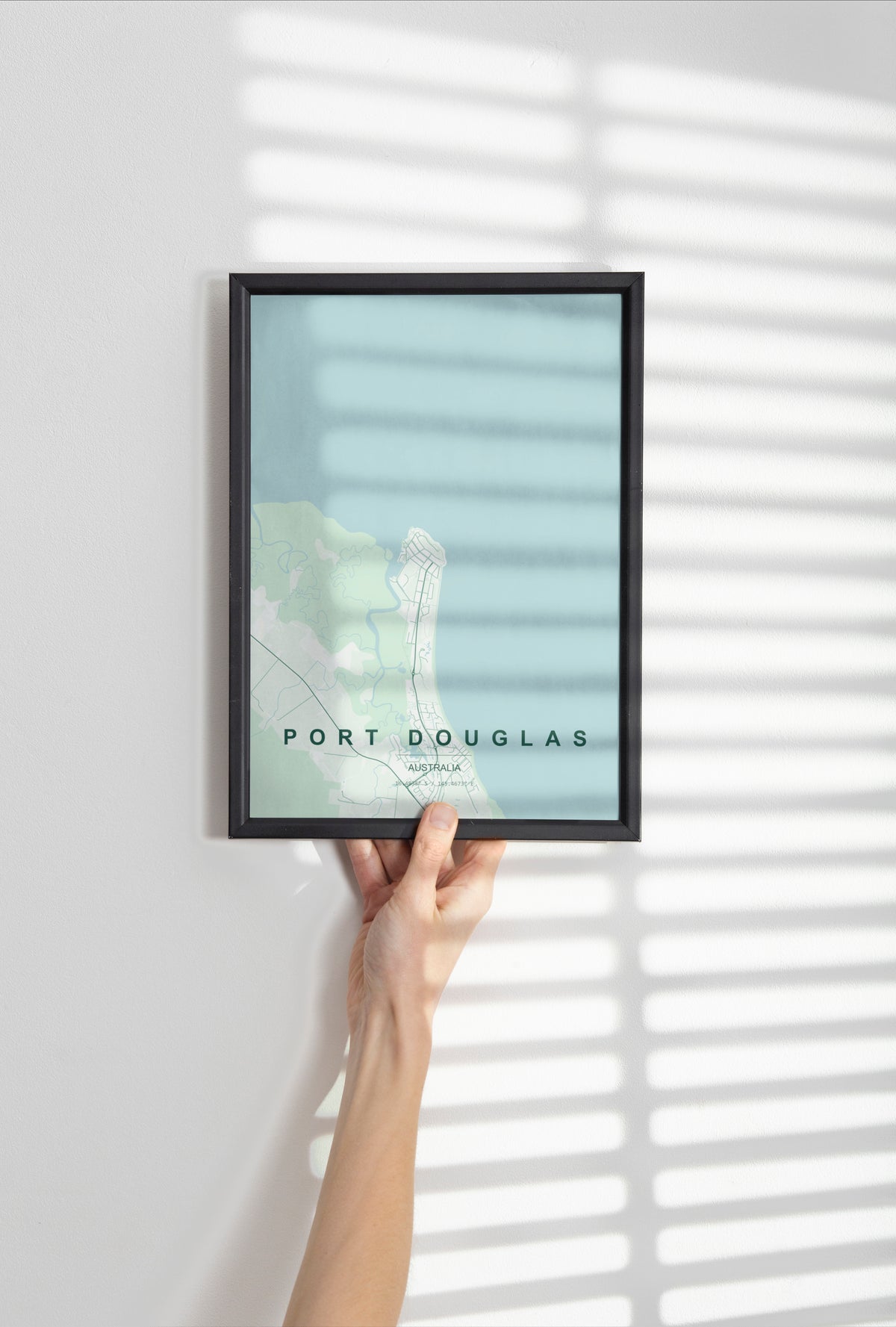 Port Douglas, Queensland, Australia map print in the Forest theme in a black frame held against a pale wall