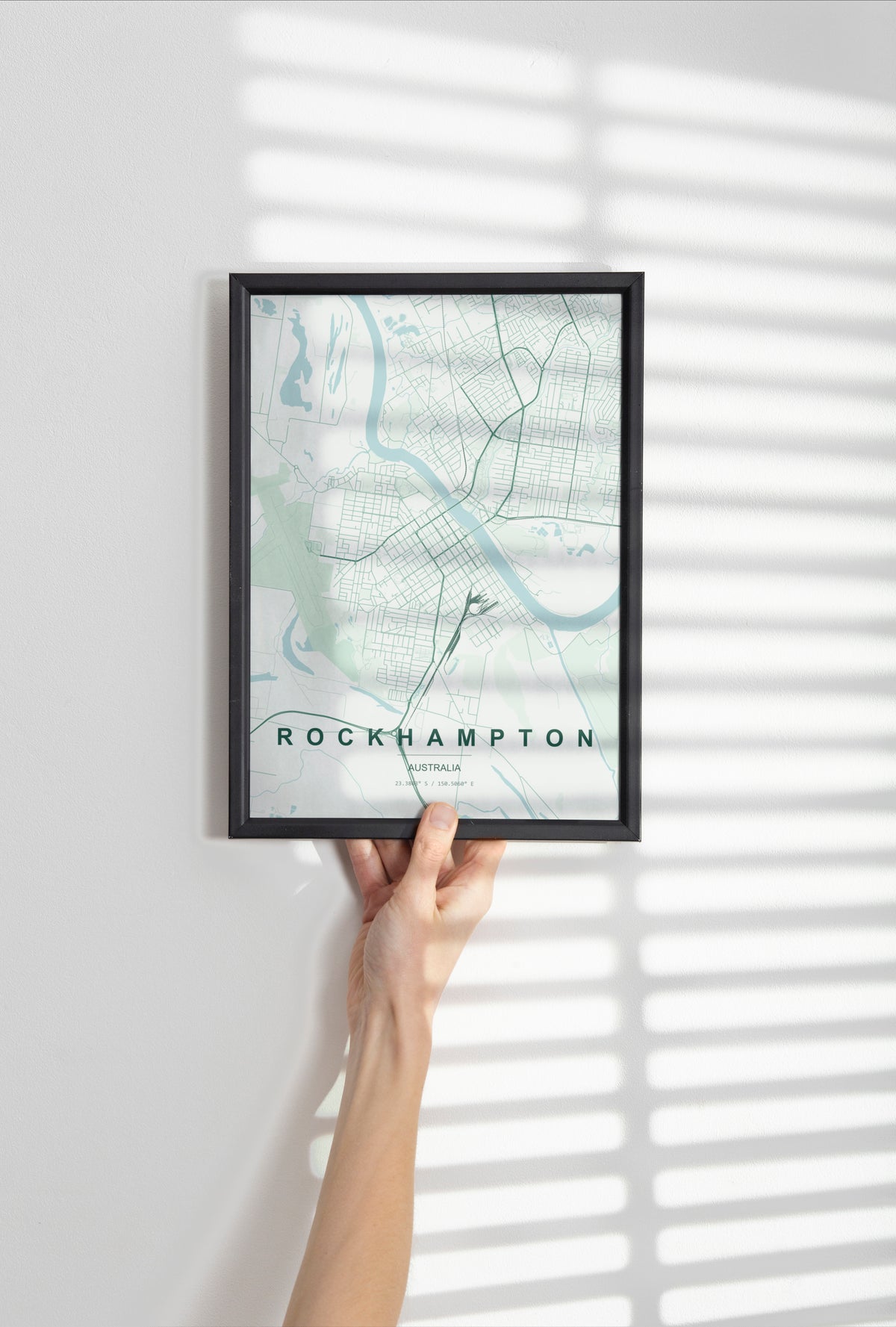 Rockhampton, Queensland, Australia map print in the Forest theme in a black frame held against a pale wall
