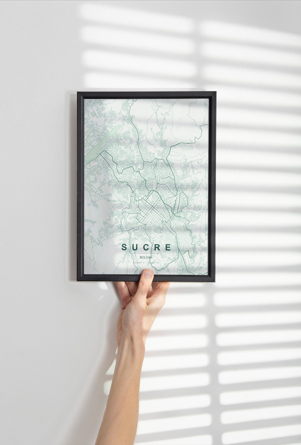 Sucre, Bolivia map print in the Forest theme in a black frame held against a pale wall