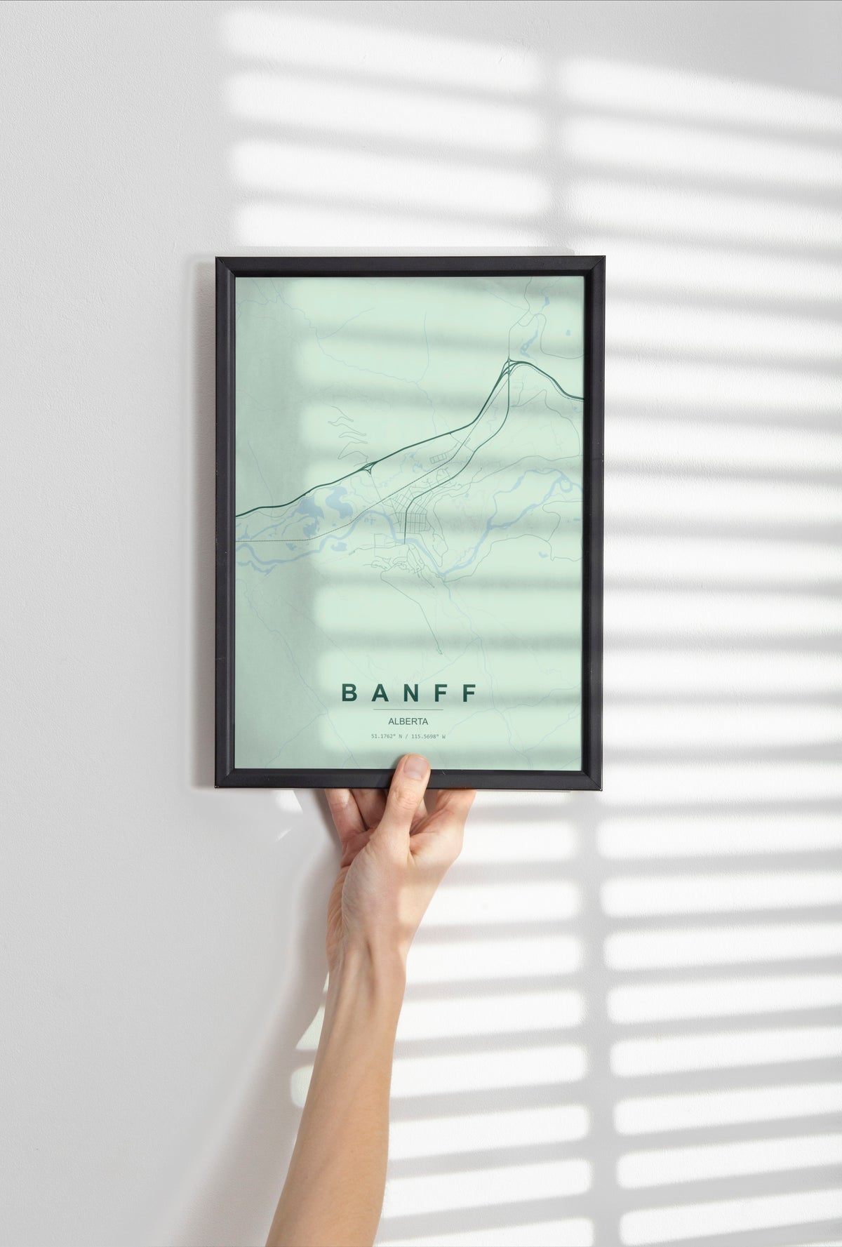 Banff, Alberta, Canada map print in the Forest theme in a black frame held against a pale wall