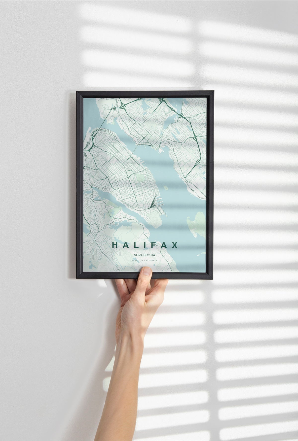 Halifax, Nova Scotia, Canada map print in the Forest theme in a black frame held against a pale wall
