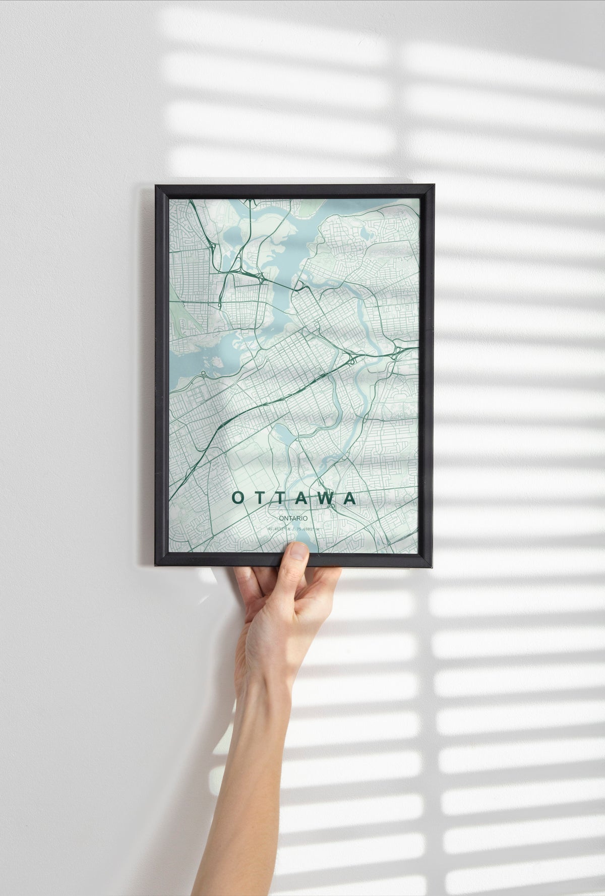 Ottawa, Ontario, Canada map print in the Forest theme in a black frame held against a pale wall