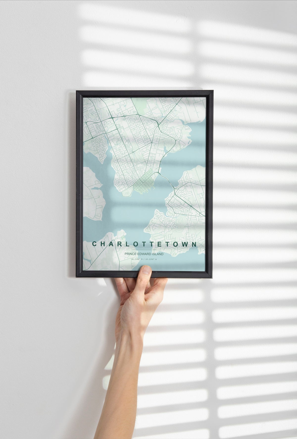 Charlottetown, Prince Edward Island, Canada map print in the Forest theme in a black frame held against a pale wall