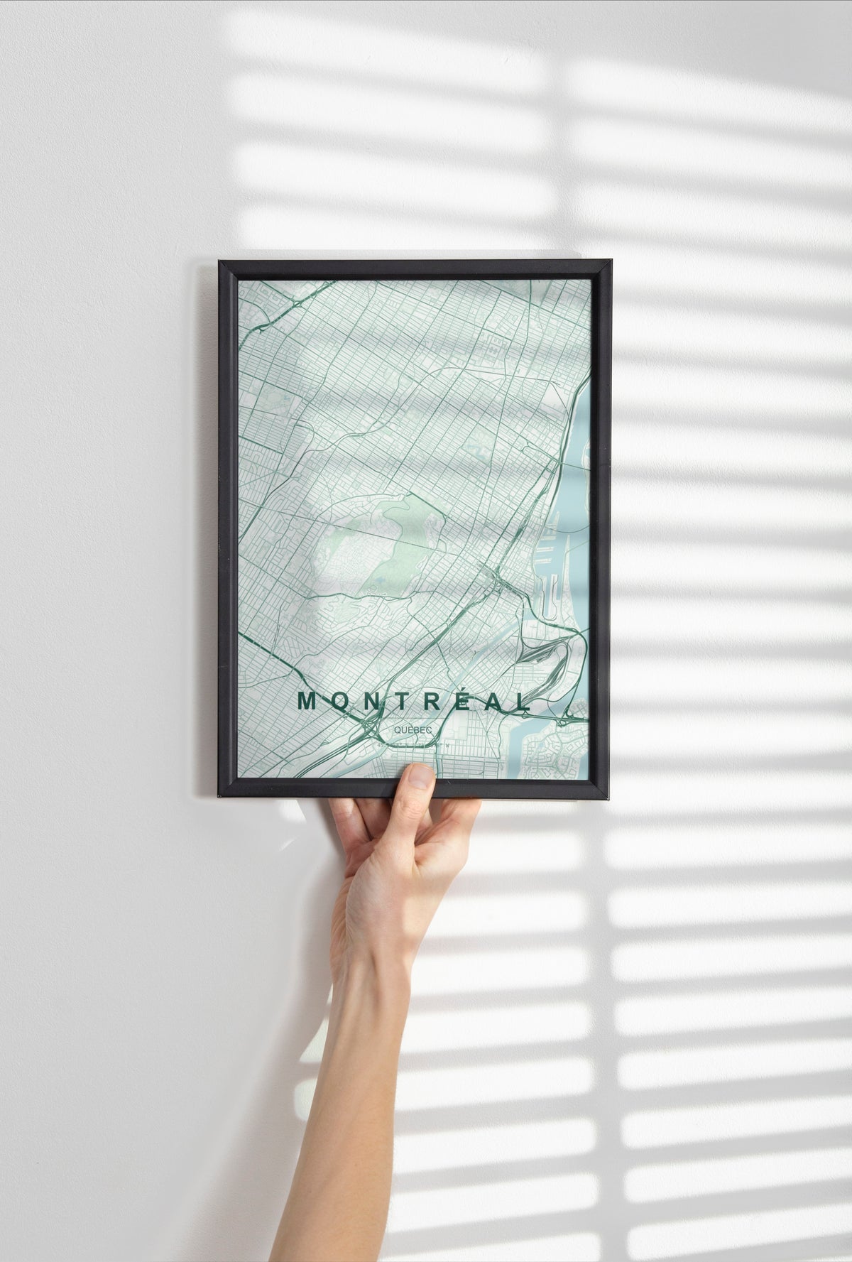 Montréal, Quebec, Canada map print in the Forest theme in a black frame held against a pale wall
