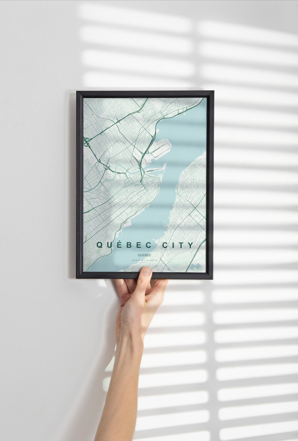 Québec City, Quebec, Canada map print in the Forest theme in a black frame held against a pale wall