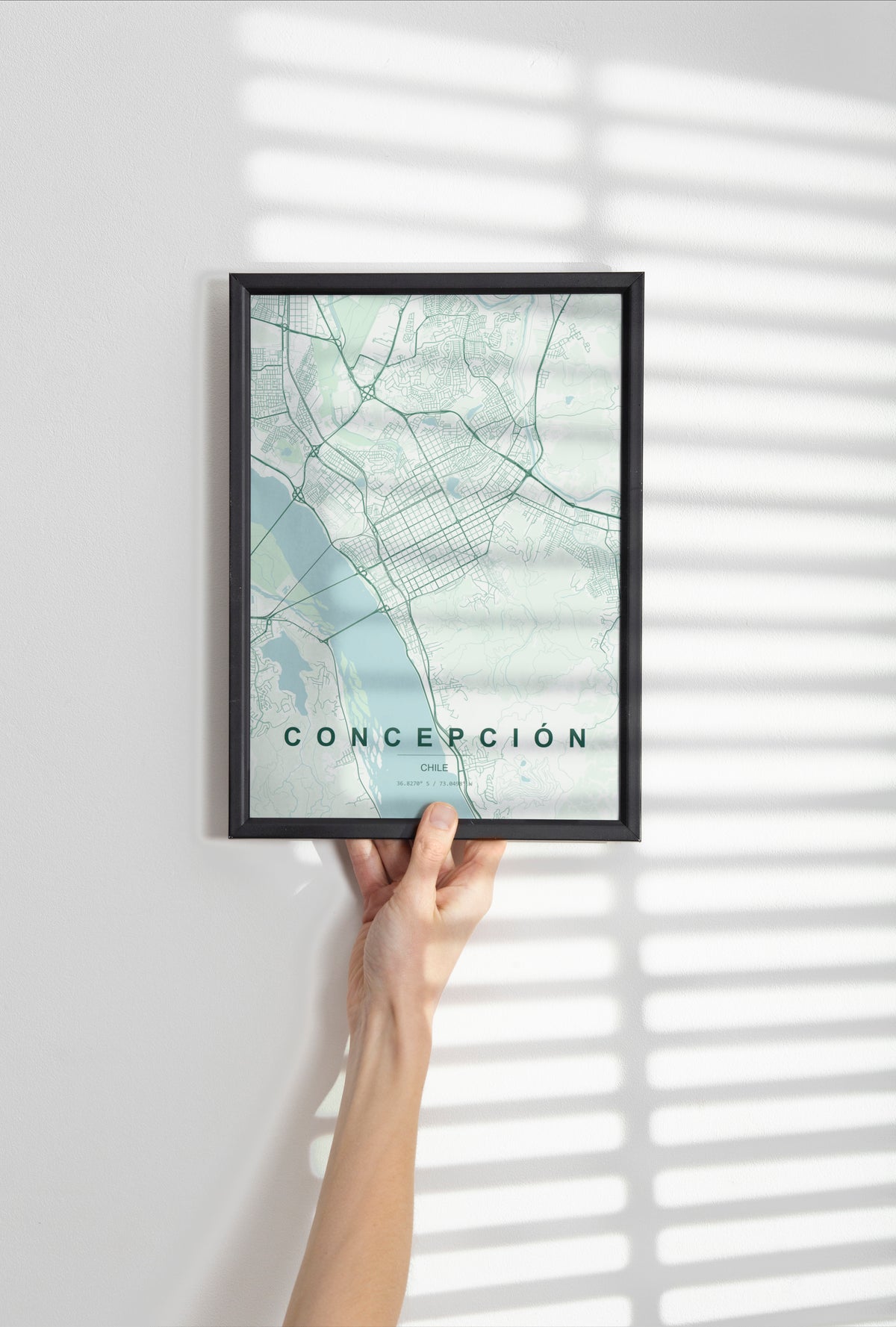 Concepción, Chile map print in the Forest theme in a black frame held against a pale wall