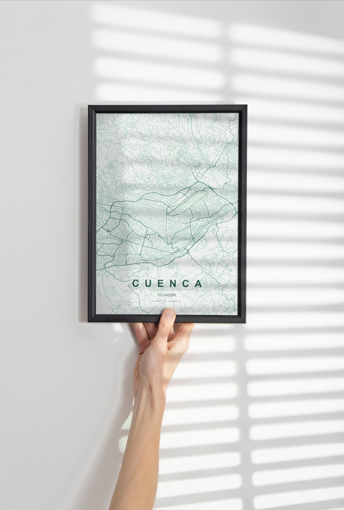 Cuenca, Ecuador map print in the Forest theme in a black frame held against a pale wall
