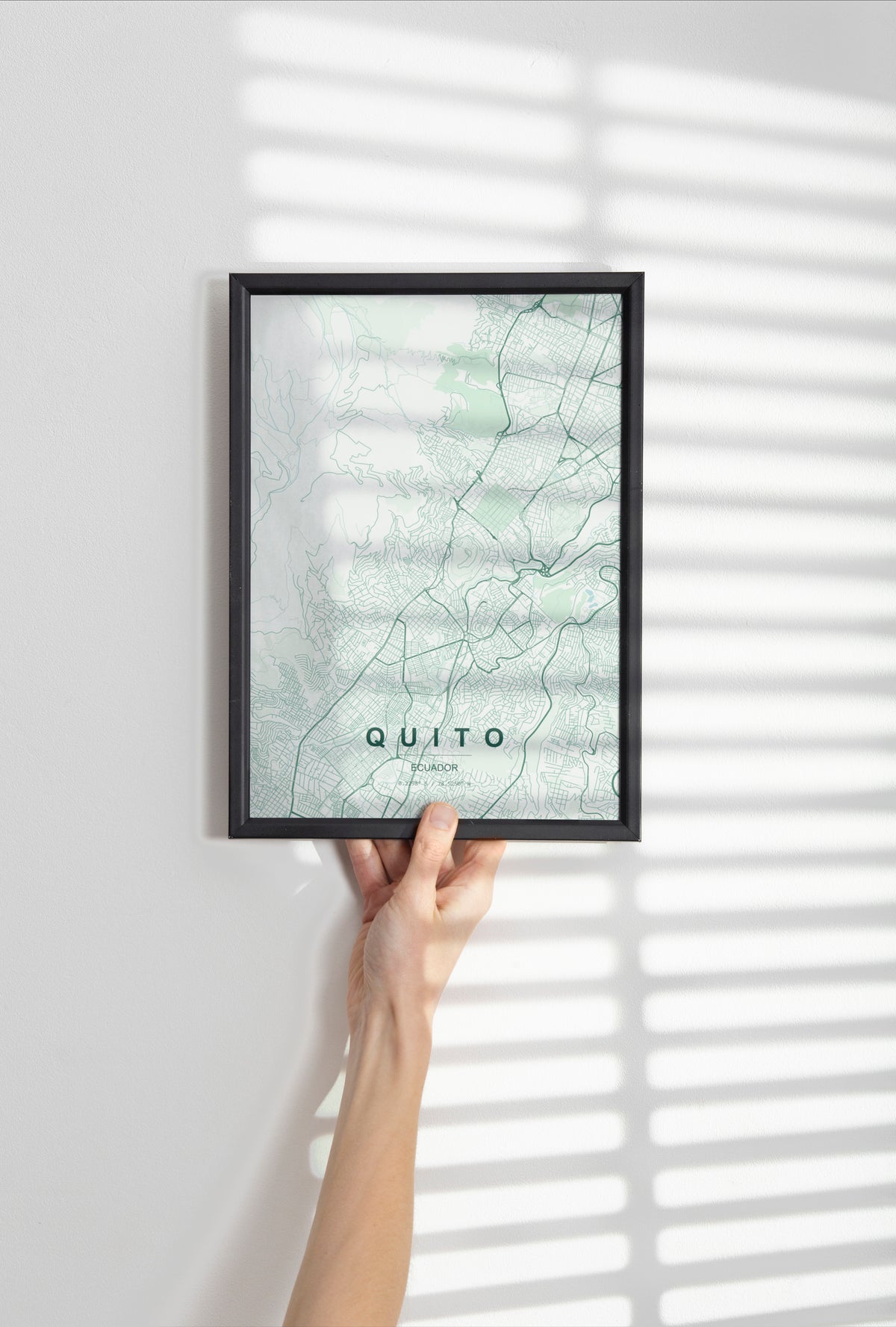 Quito, Ecuador map print in the Forest theme in a black frame held against a pale wall