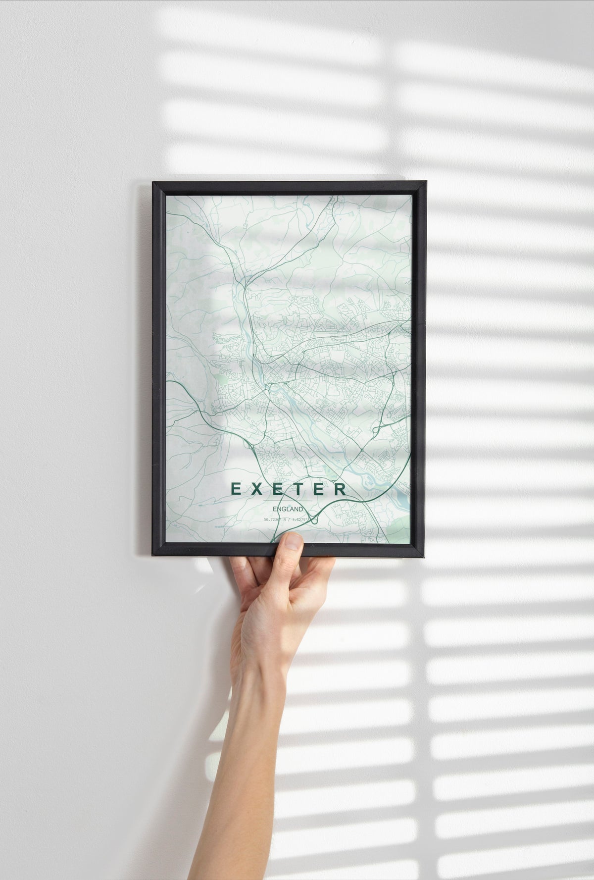 Exeter, England, United Kingdom map print in the Forest theme in a black frame held against a pale wall