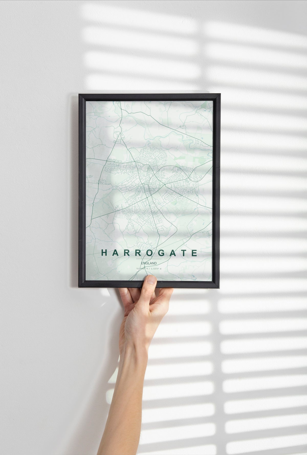 Harrogate, England, United Kingdom map print in the Forest theme in a black frame held against a pale wall