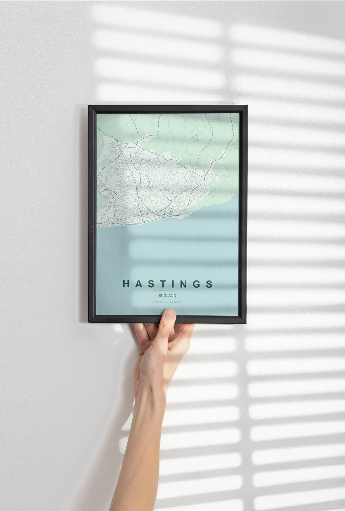 Hastings, England, United Kingdom map print in the Forest theme in a black frame held against a pale wall