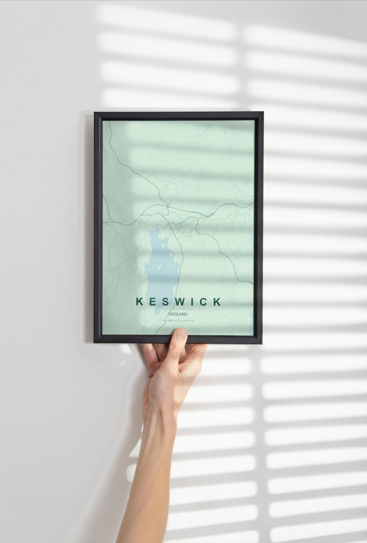 Keswick, England, United Kingdom map print in the Forest theme in a black frame held against a pale wall