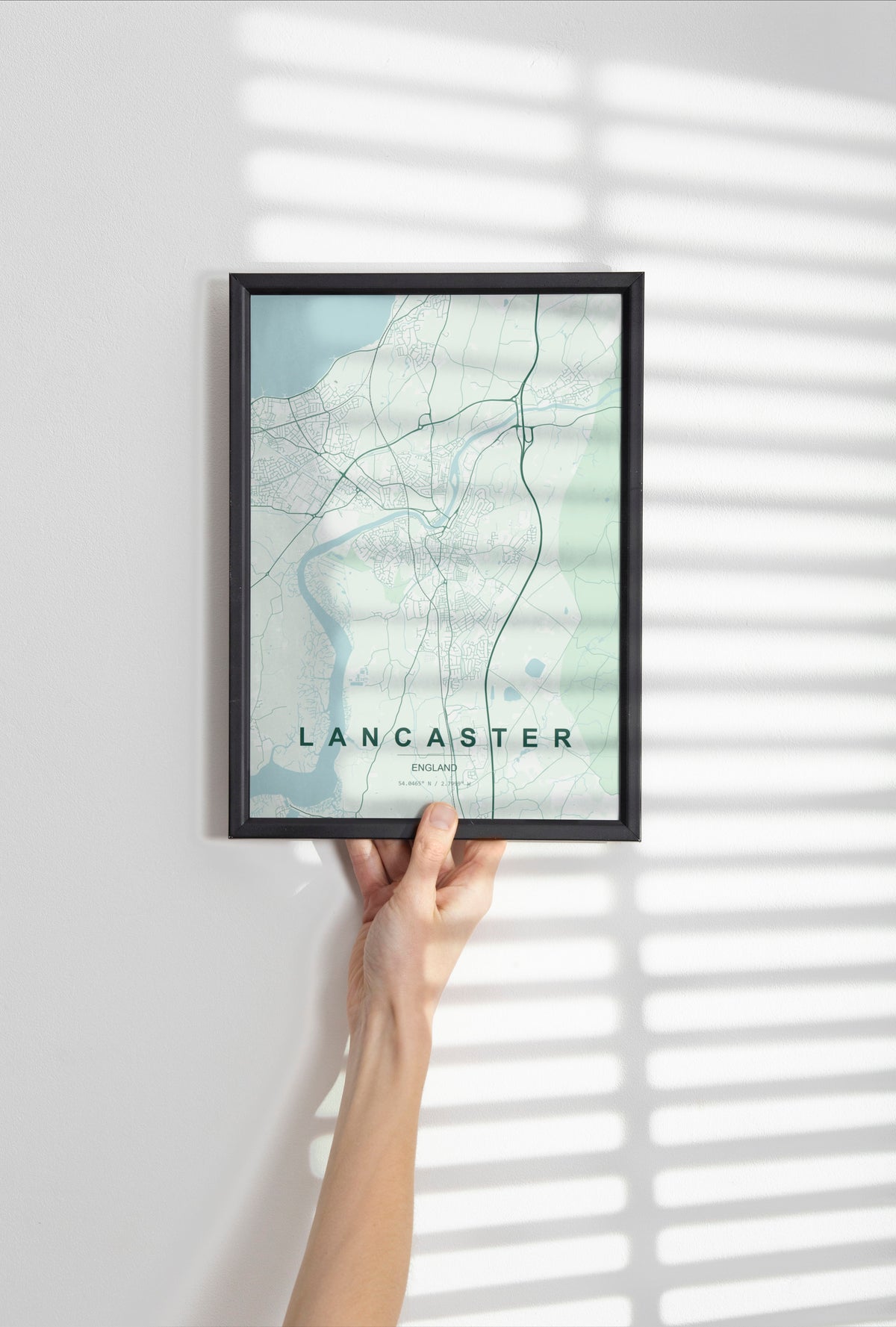 Lancaster, England, United Kingdom map print in the Forest theme in a black frame held against a pale wall