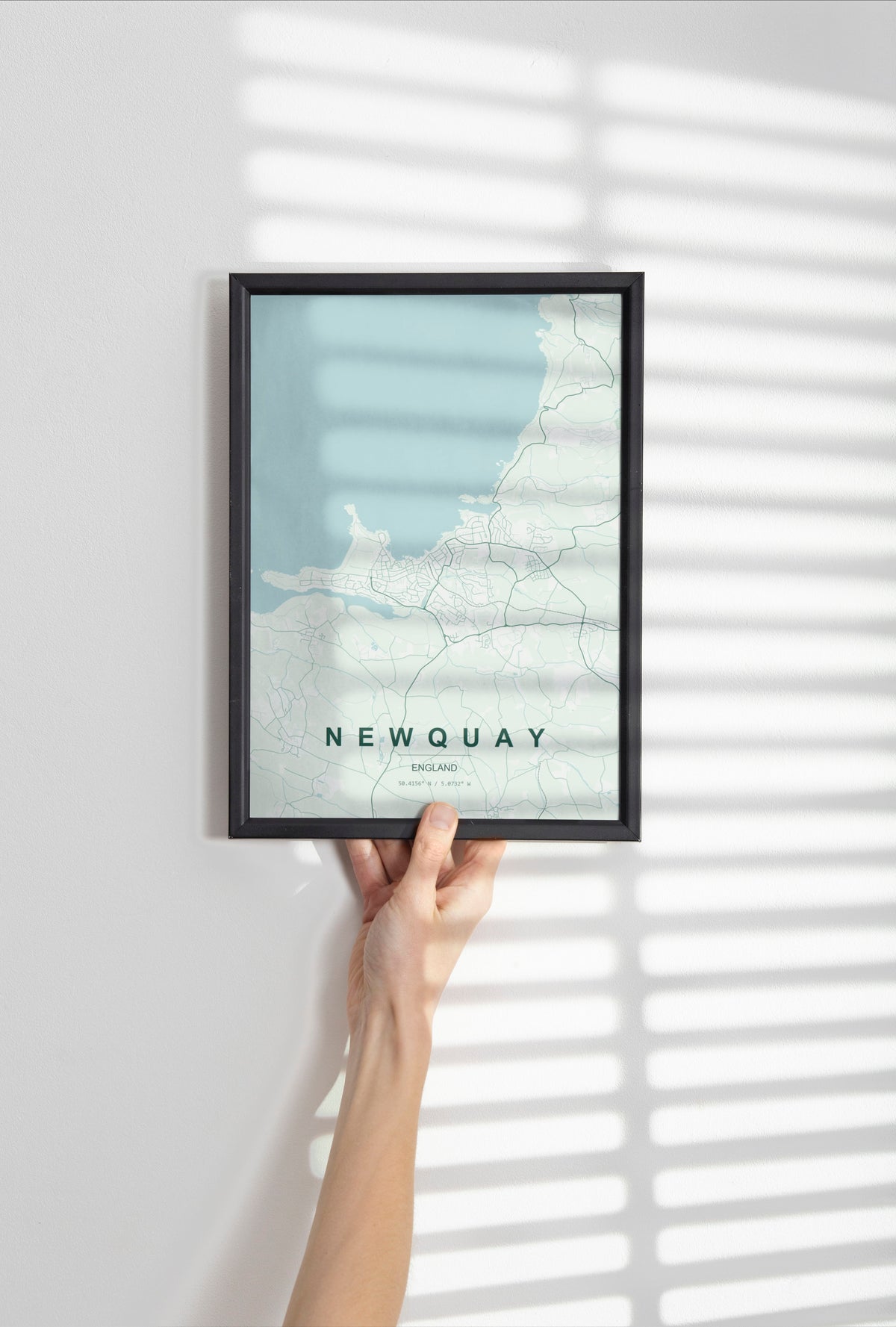 Newquay, England, United Kingdom map print in the Forest theme in a black frame held against a pale wall