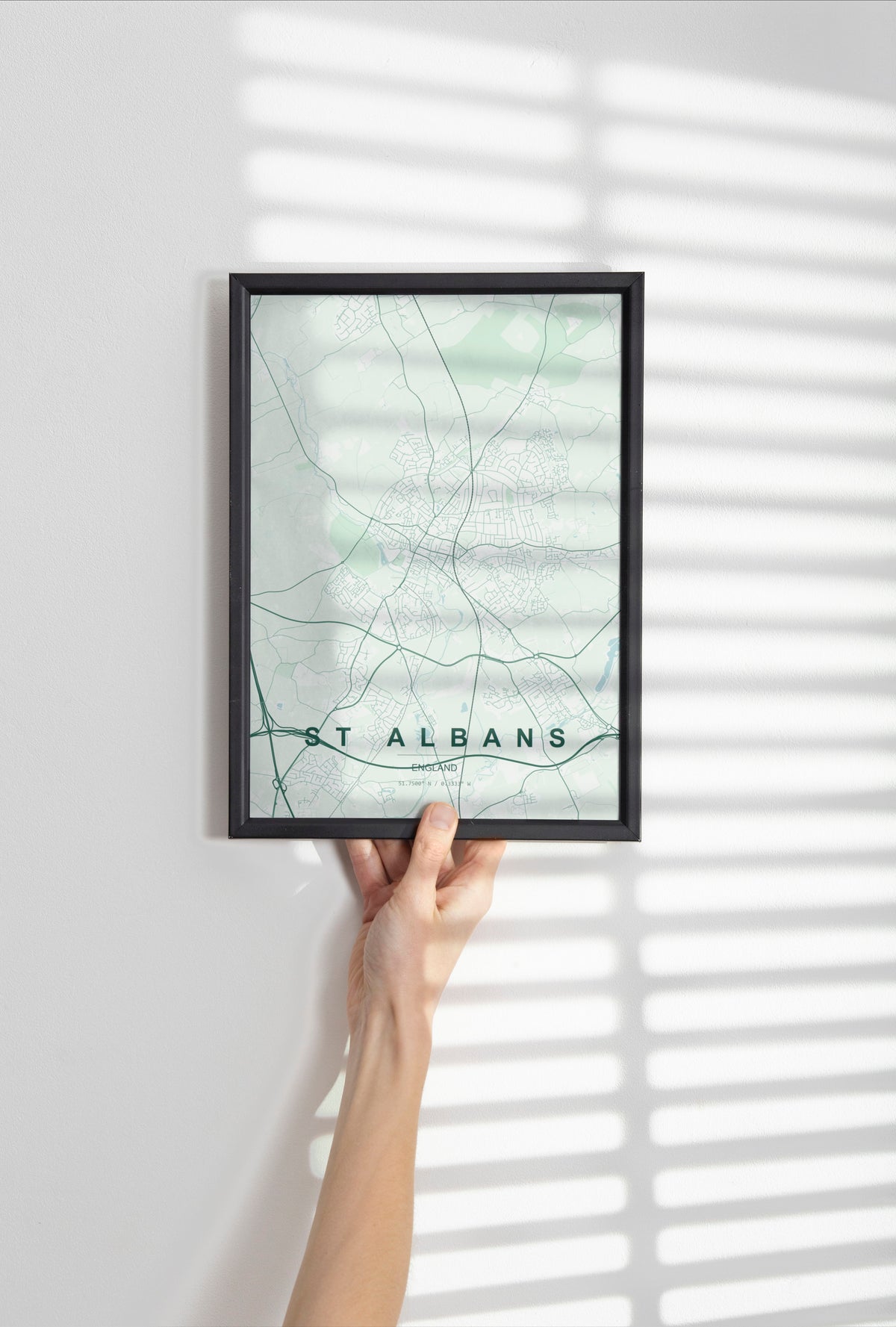 St Albans, England, United Kingdom map print in the Forest theme in a black frame held against a pale wall