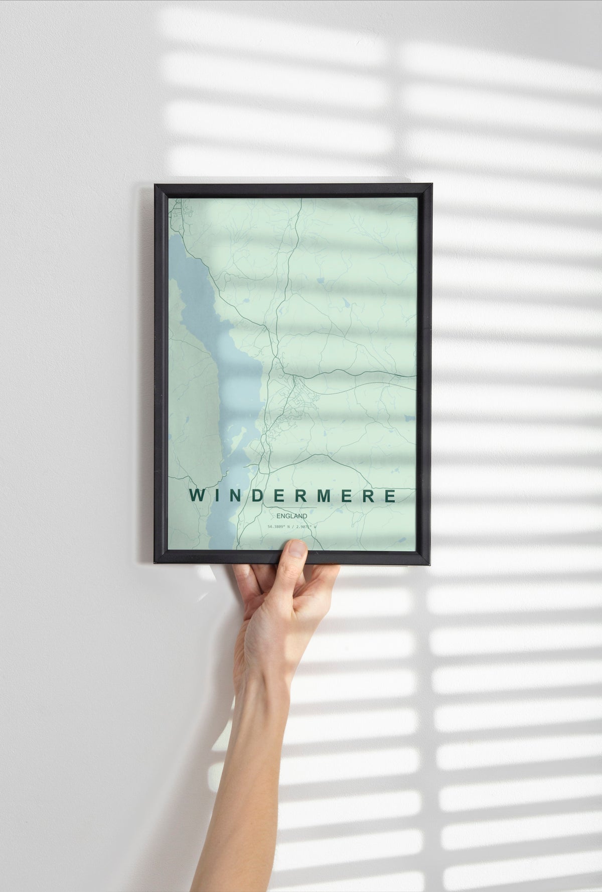 Windermere, England, United Kingdom map print in the Forest theme in a black frame held against a pale wall