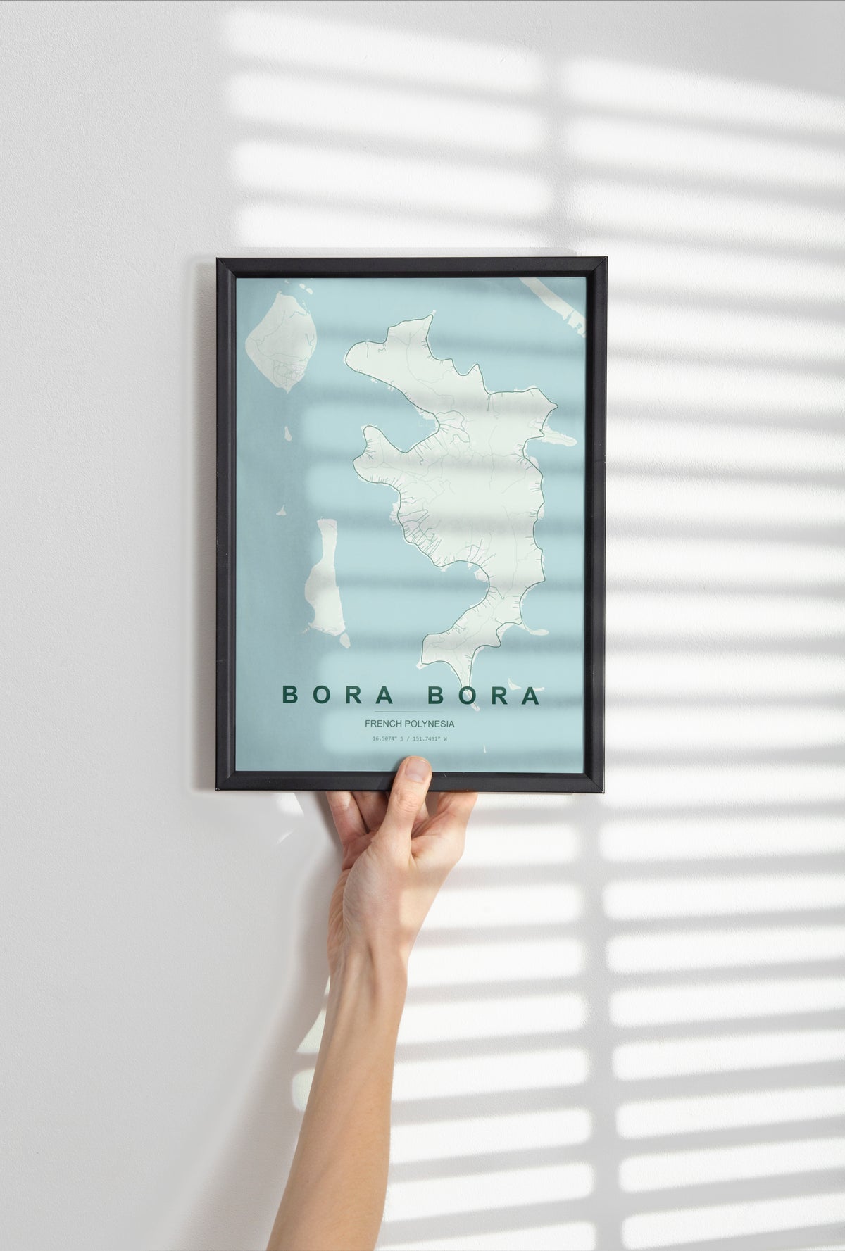 Bora Bora, French Polynesia, France map print in the Forest theme in a black frame held against a pale wall