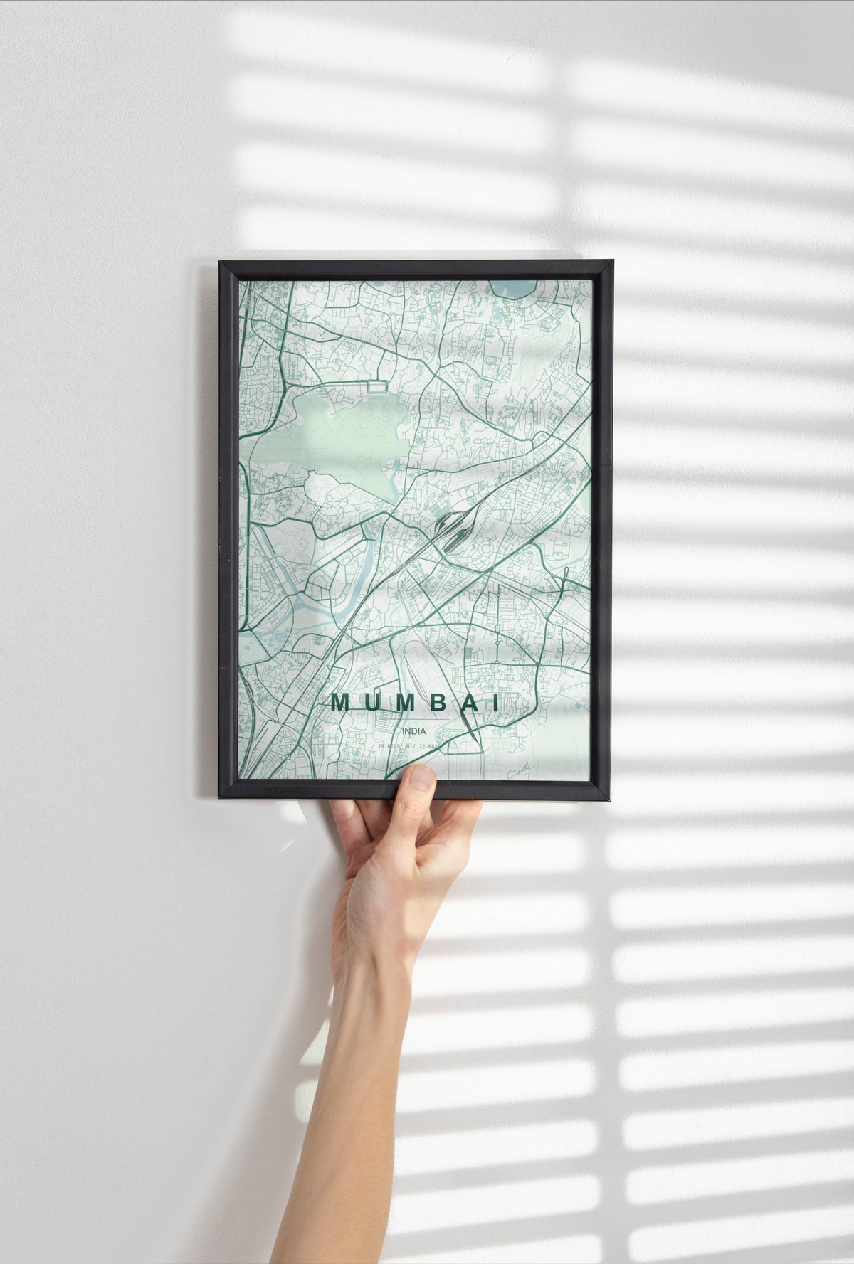 Mumbai, India map print in the Forest theme in a black frame held against a pale wall