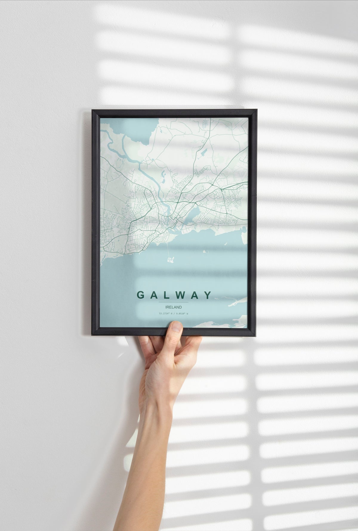 Galway map print in the Forest theme in a black frame held against a pale wall