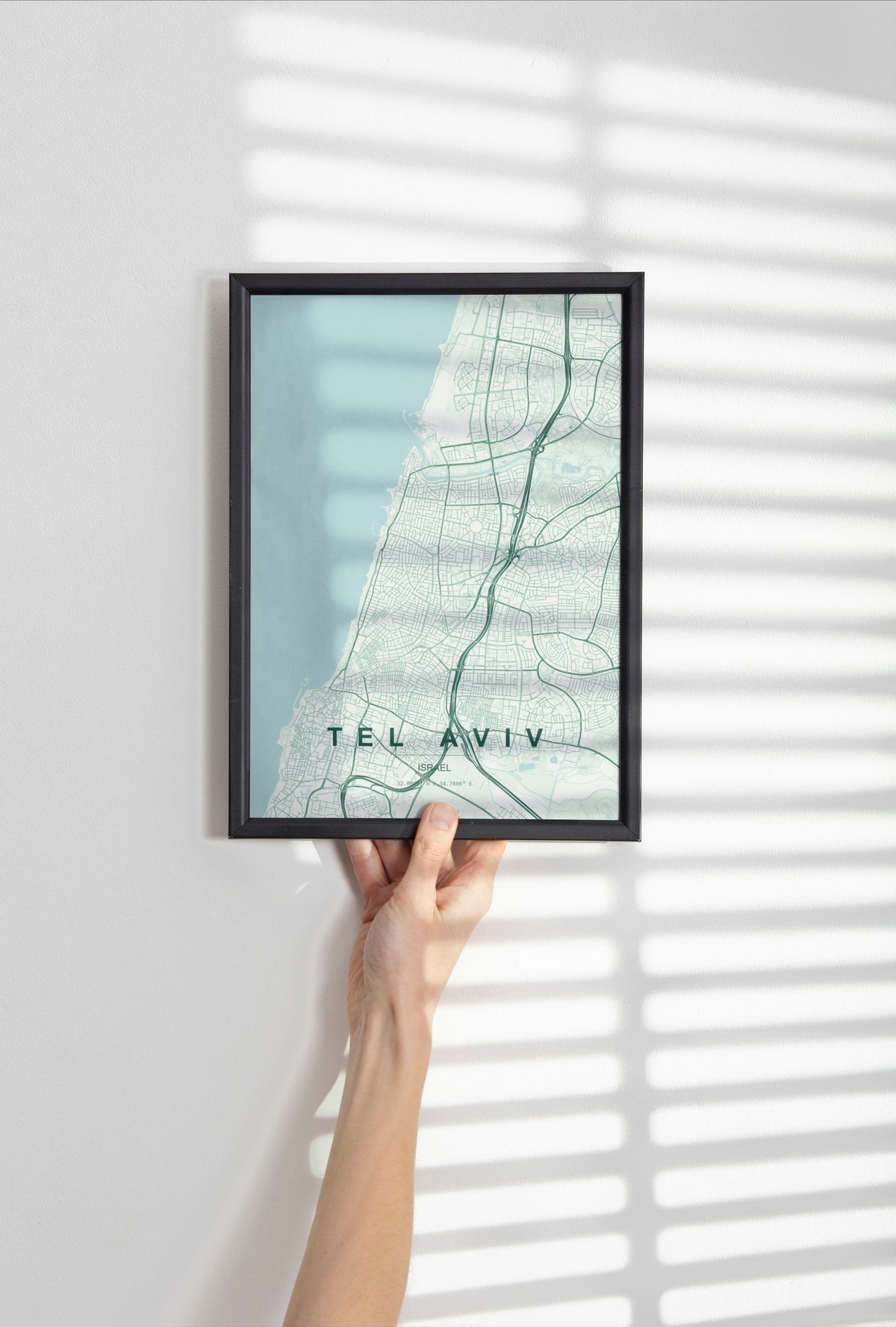Tel Aviv, Israel map print in the Forest theme in a black frame held against a pale wall