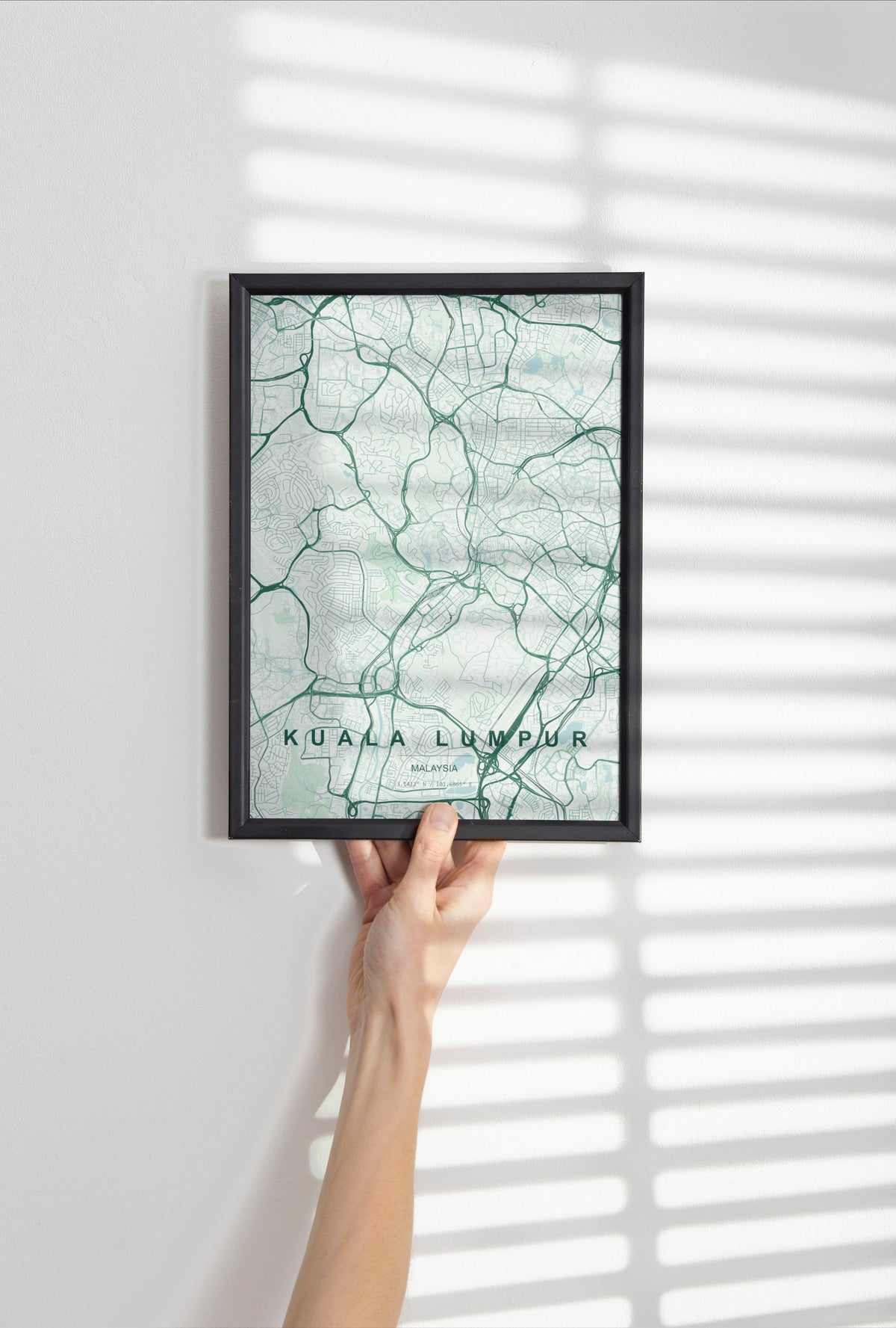 Kuala Lumpur, Malaysia map print in the Forest theme in a black frame held against a pale wall