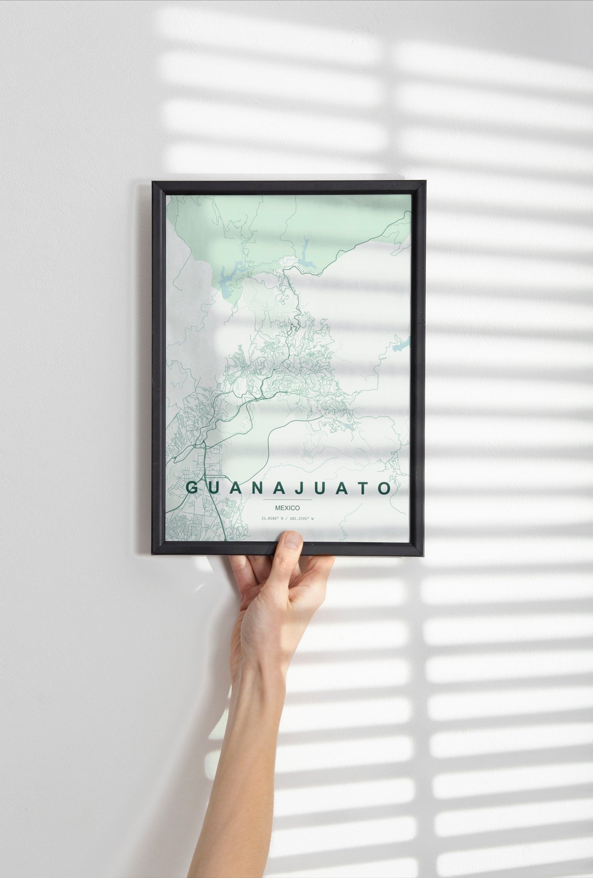 Guanajuato, Mexico map print in the Forest theme in a black frame held against a pale wall