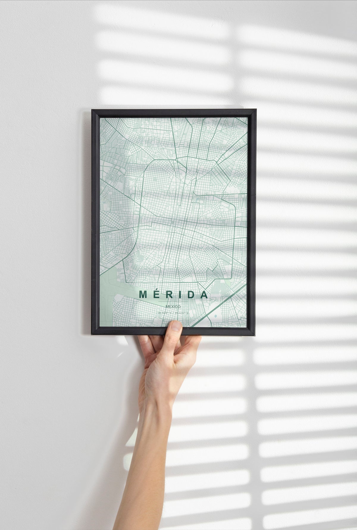 Mérida, Mexico map print in the Forest theme in a black frame held against a pale wall