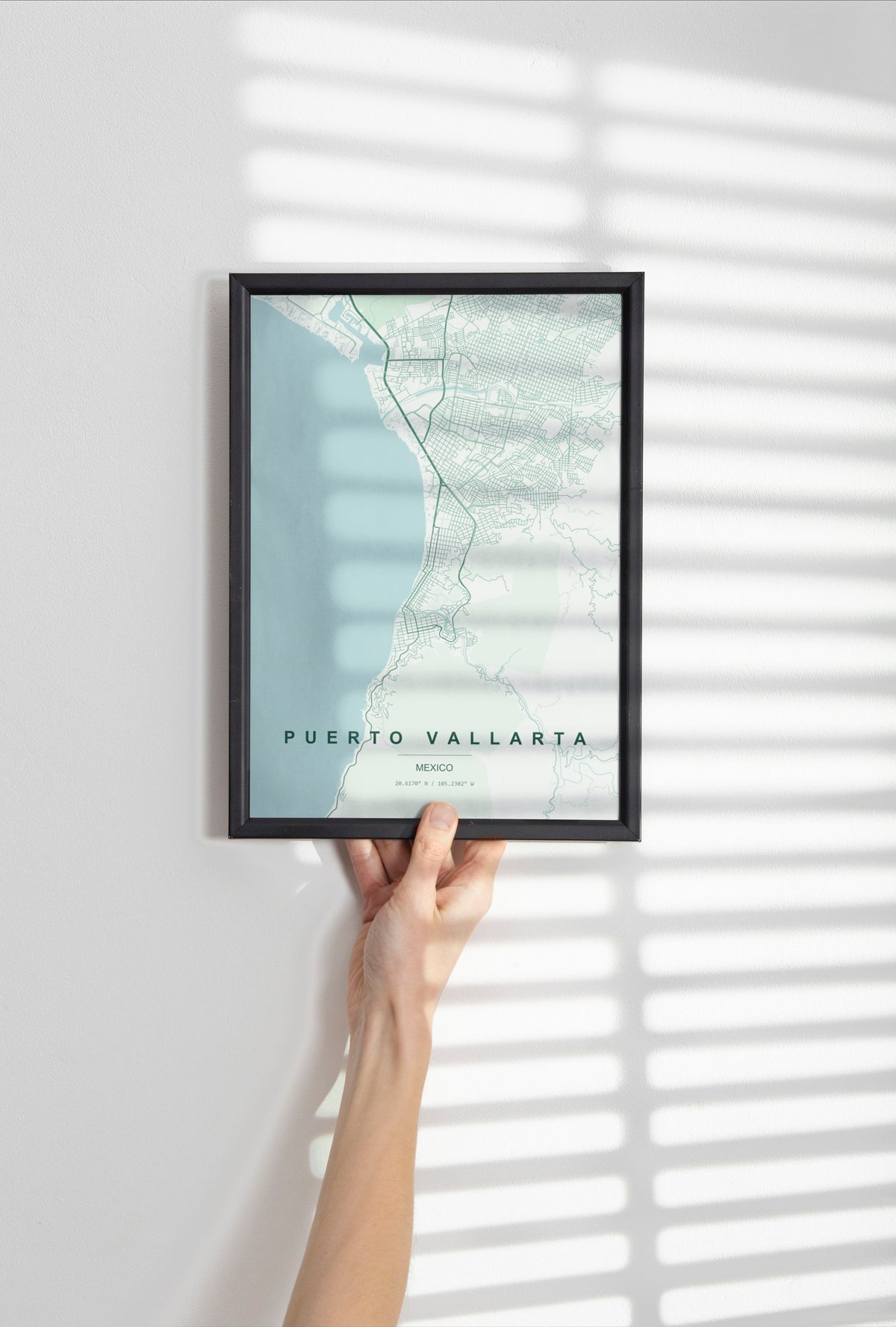 Puerto Vallarta, Mexico map print in the Forest theme in a black frame held against a pale wall
