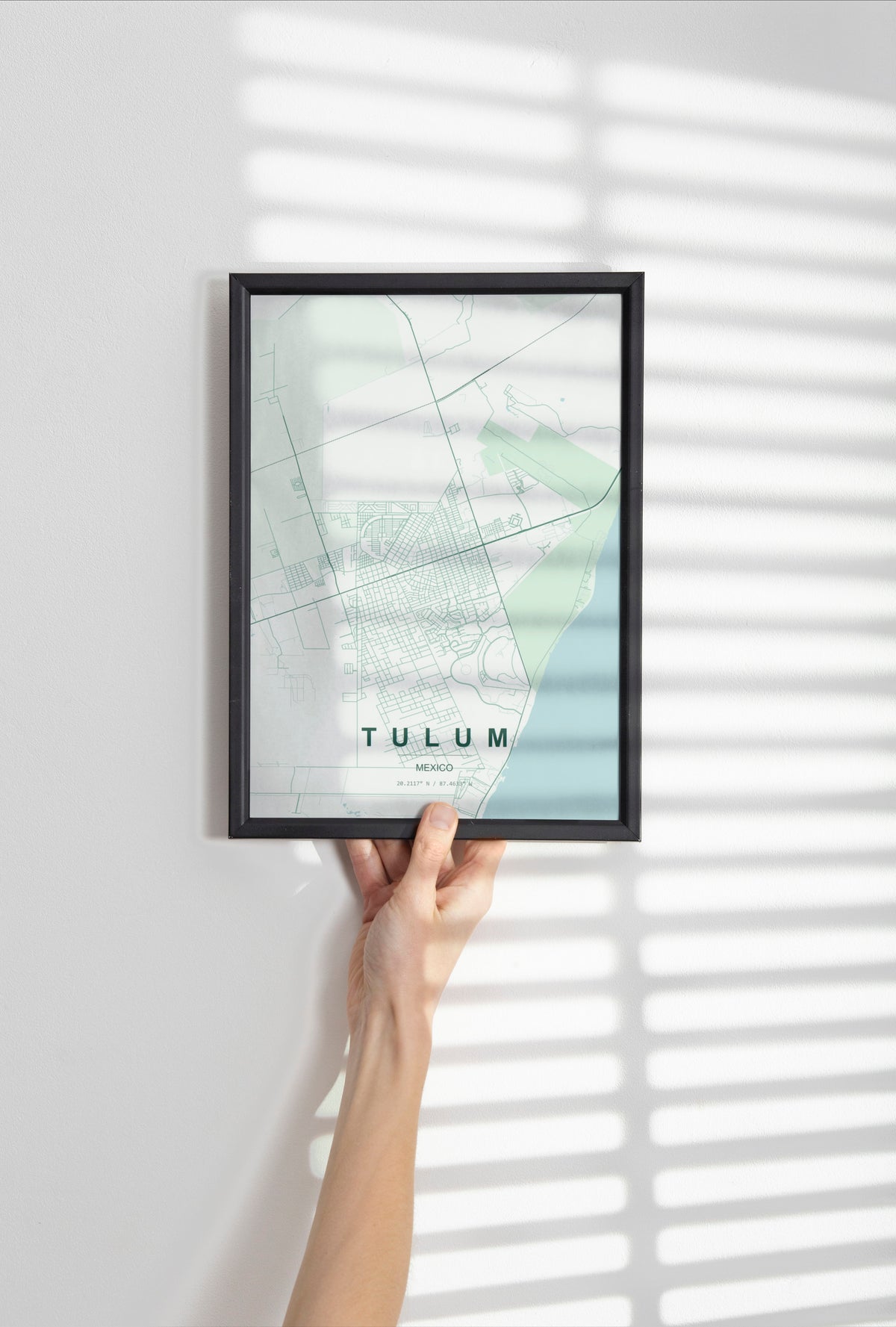 Tulum, Mexico map print in the Forest theme in a black frame held against a pale wall