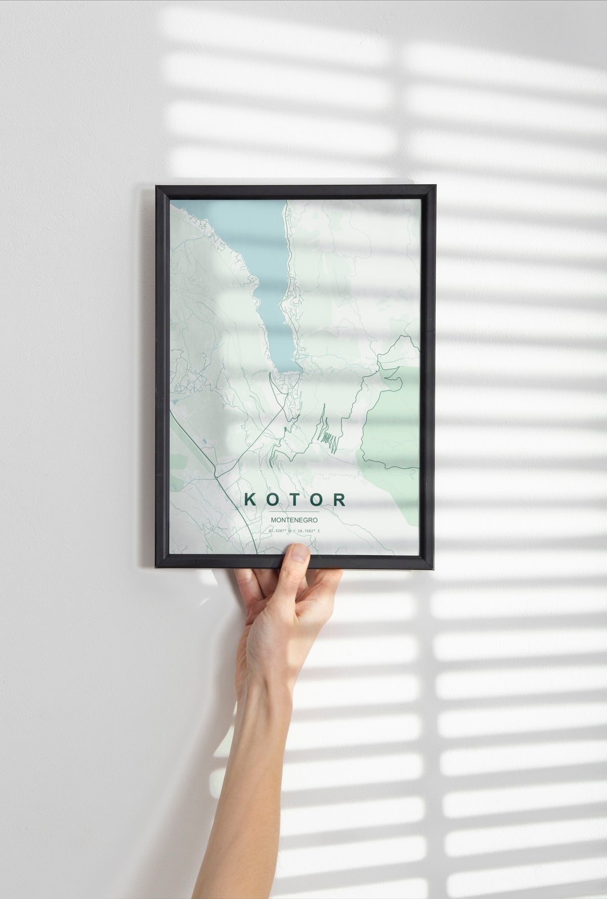 Kotor map print in the Forest theme in a black frame held against a pale wall