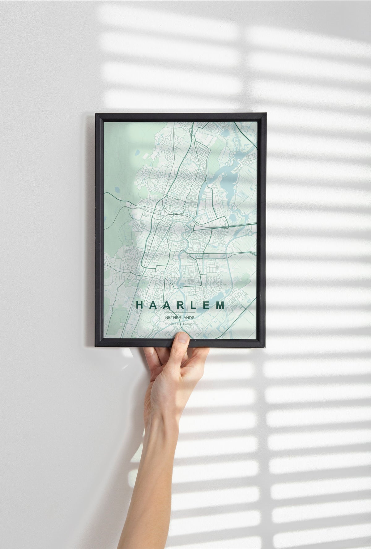 Haarlem map print in the Forest theme in a black frame held against a pale wall