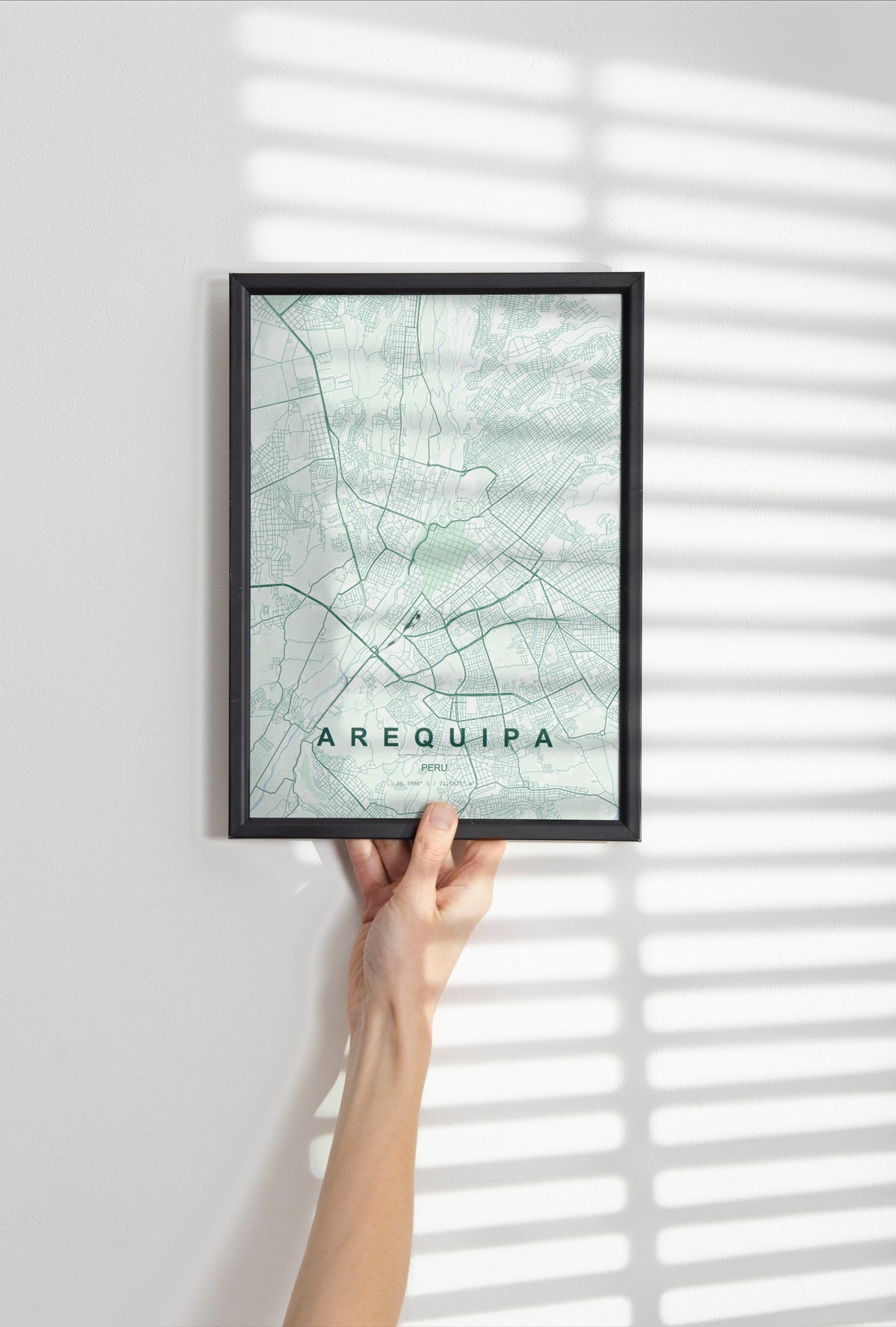 Arequipa, Peru map print in the Forest theme in a black frame held against a pale wall