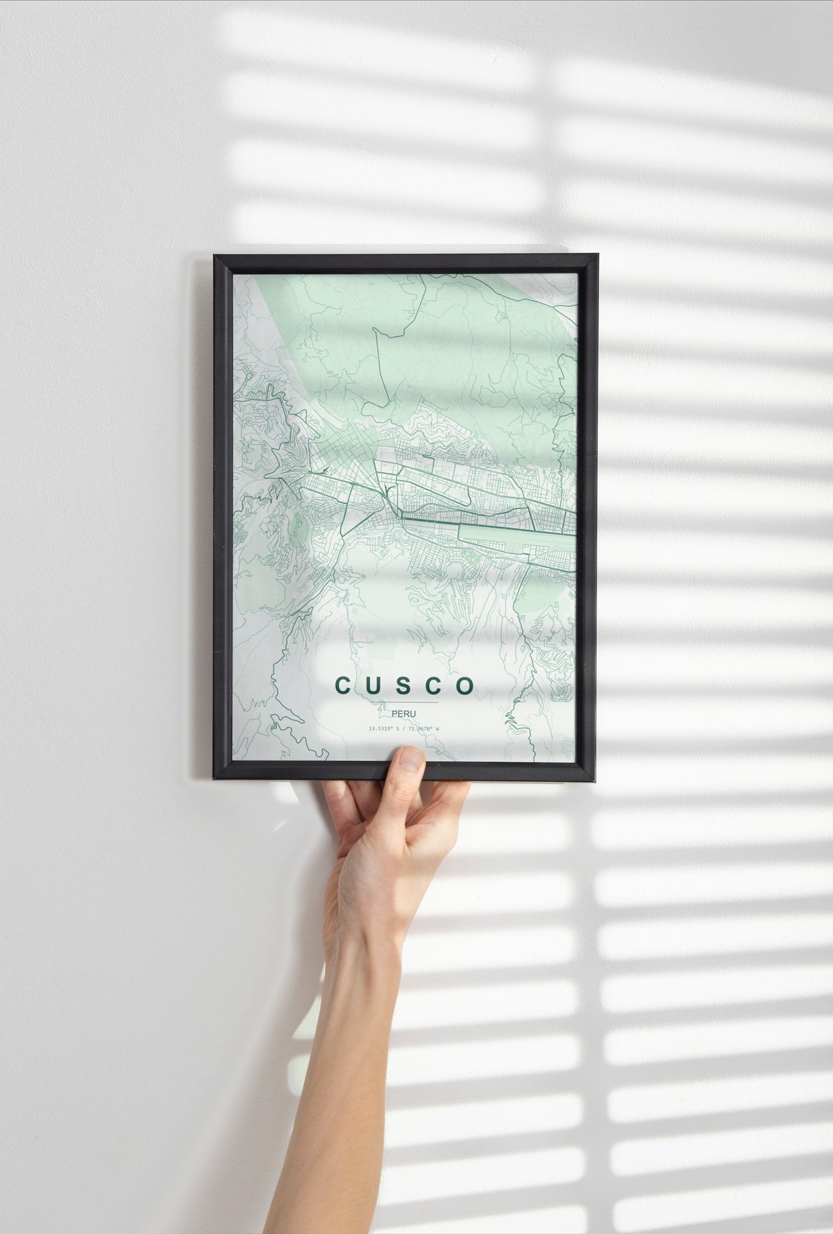 Cusco, Peru map print in the Forest theme in a black frame held against a pale wall