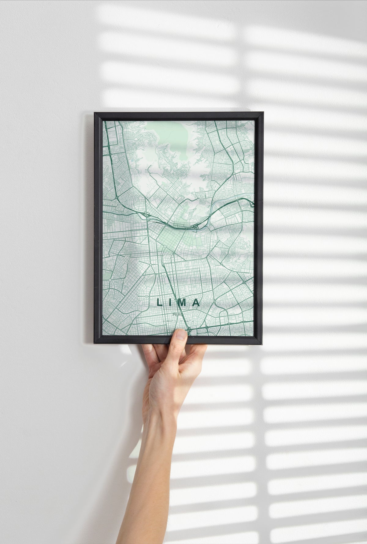 Lima, Peru map print in the Forest theme in a black frame held against a pale wall