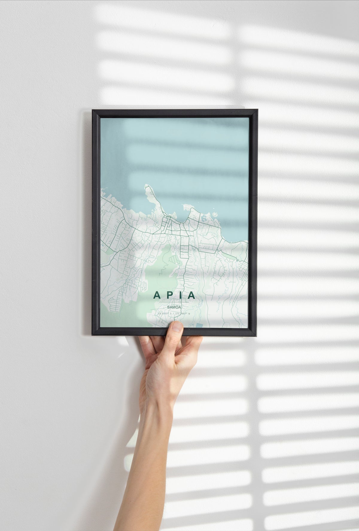 Apia, Samoa map print in the Forest theme in a black frame held against a pale wall