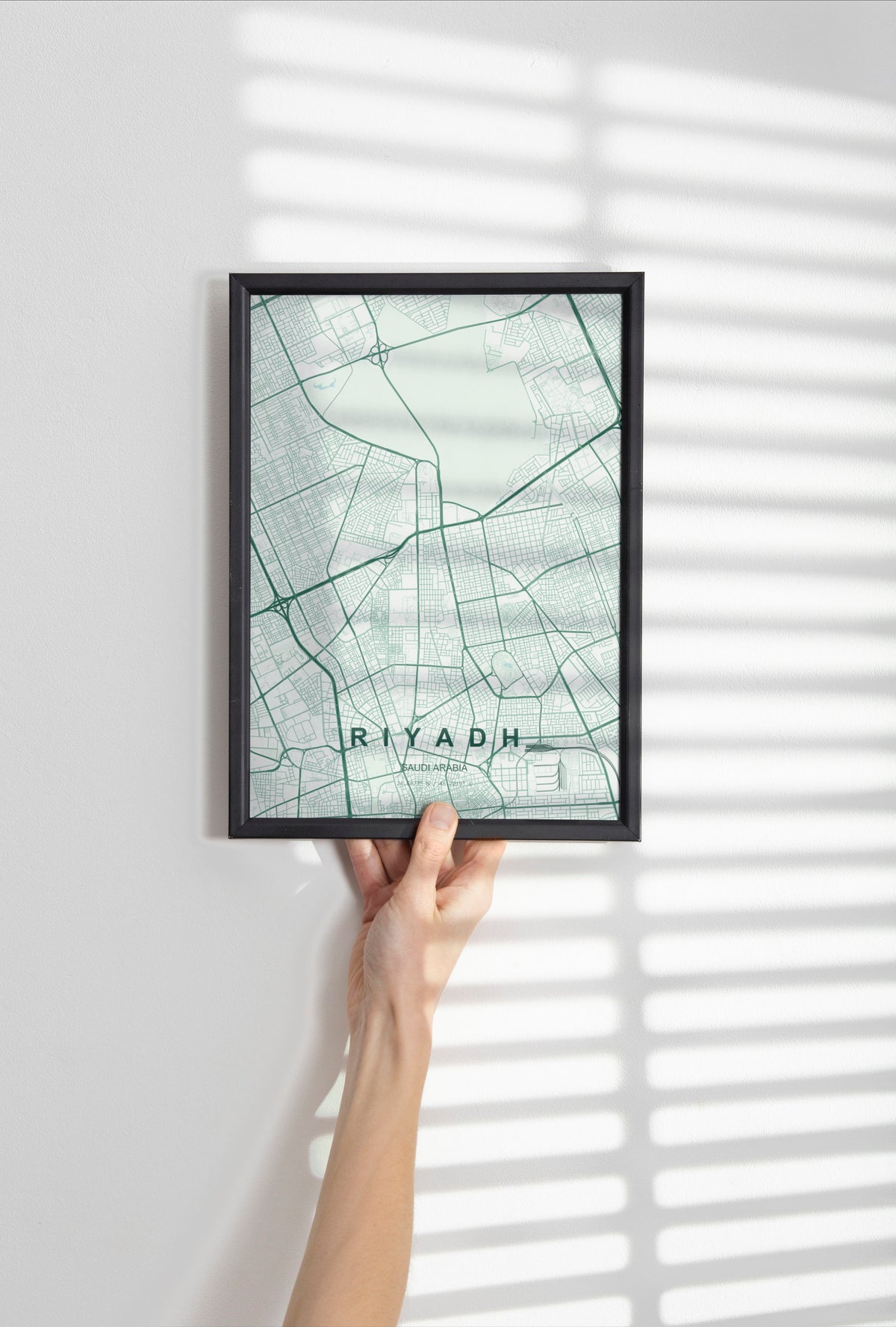 Riyadh, Saudi Arabia map print in the Forest theme in a black frame held against a pale wall
