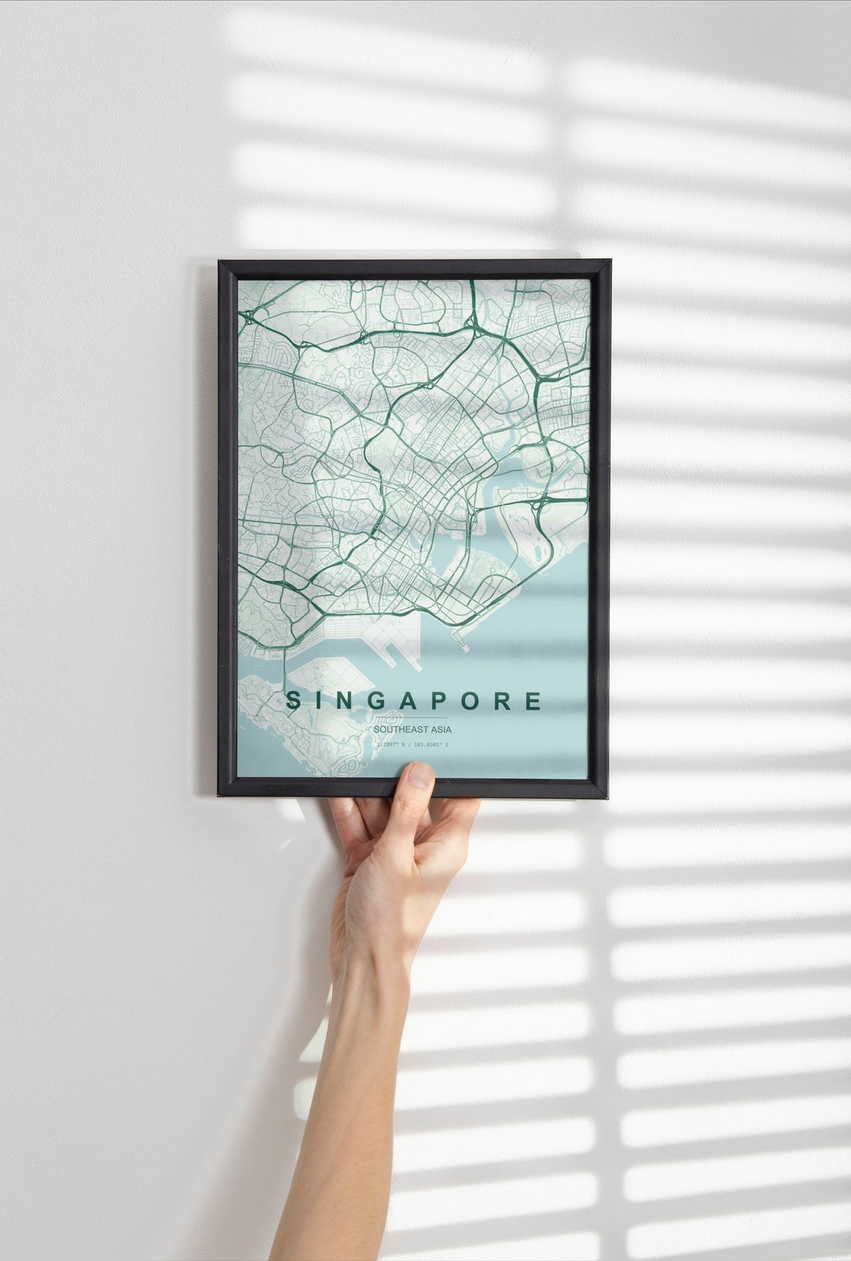 Singapore, map print in the Forest theme in a black frame held against a pale wall