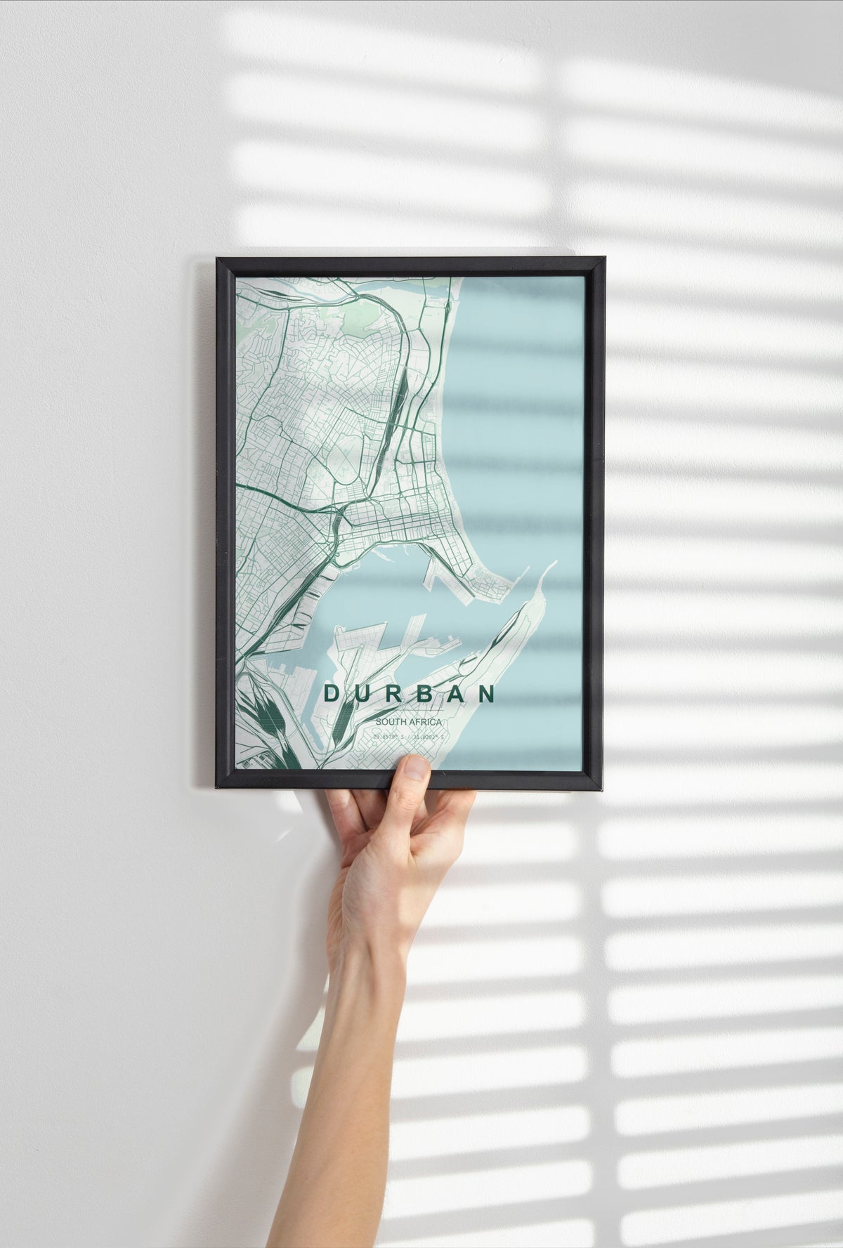 Durban, KwaZulu-Natal, South Africa map print in the Forest theme in a black frame held against a pale wall