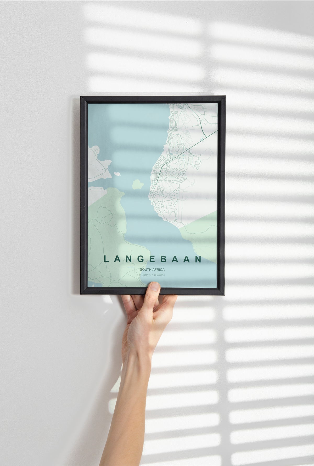 Langebaan, Western Cape, South Africa map print in the Forest theme in a black frame held against a pale wall
