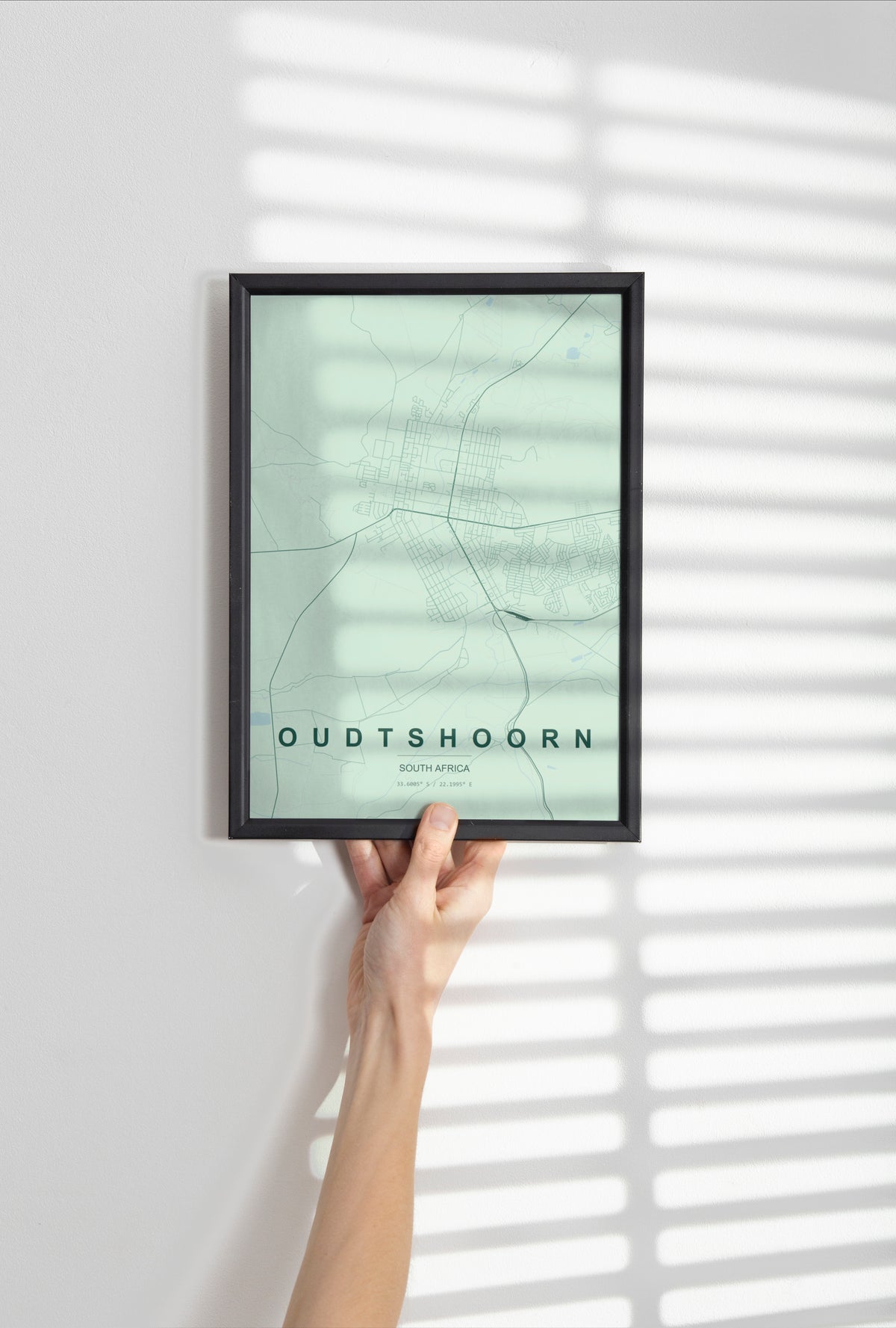 Oudtshoorn, Western Cape, South Africa map print in the Forest theme in a black frame held against a pale wall