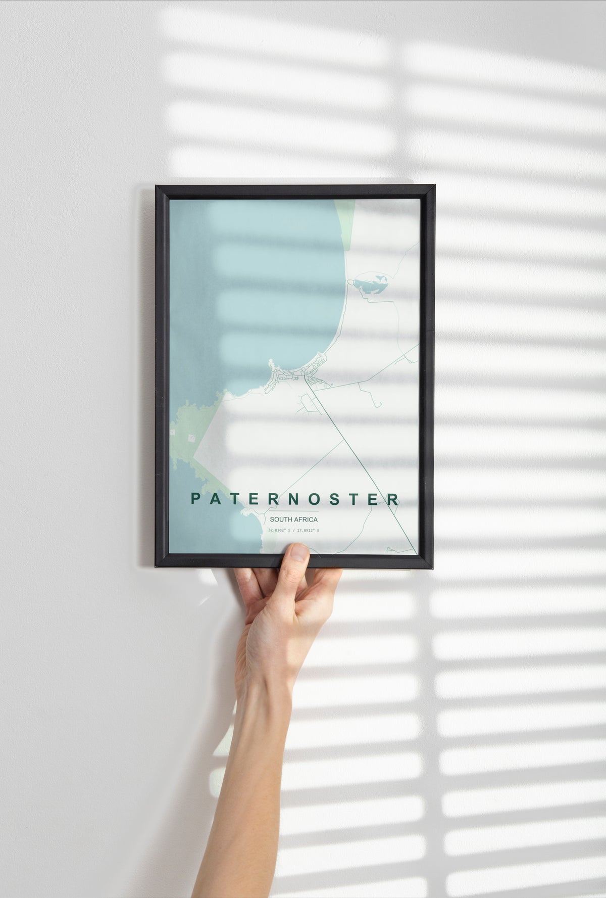 Paternoster, Western Cape, South Africa map print in the Forest theme in a black frame held against a pale wall
