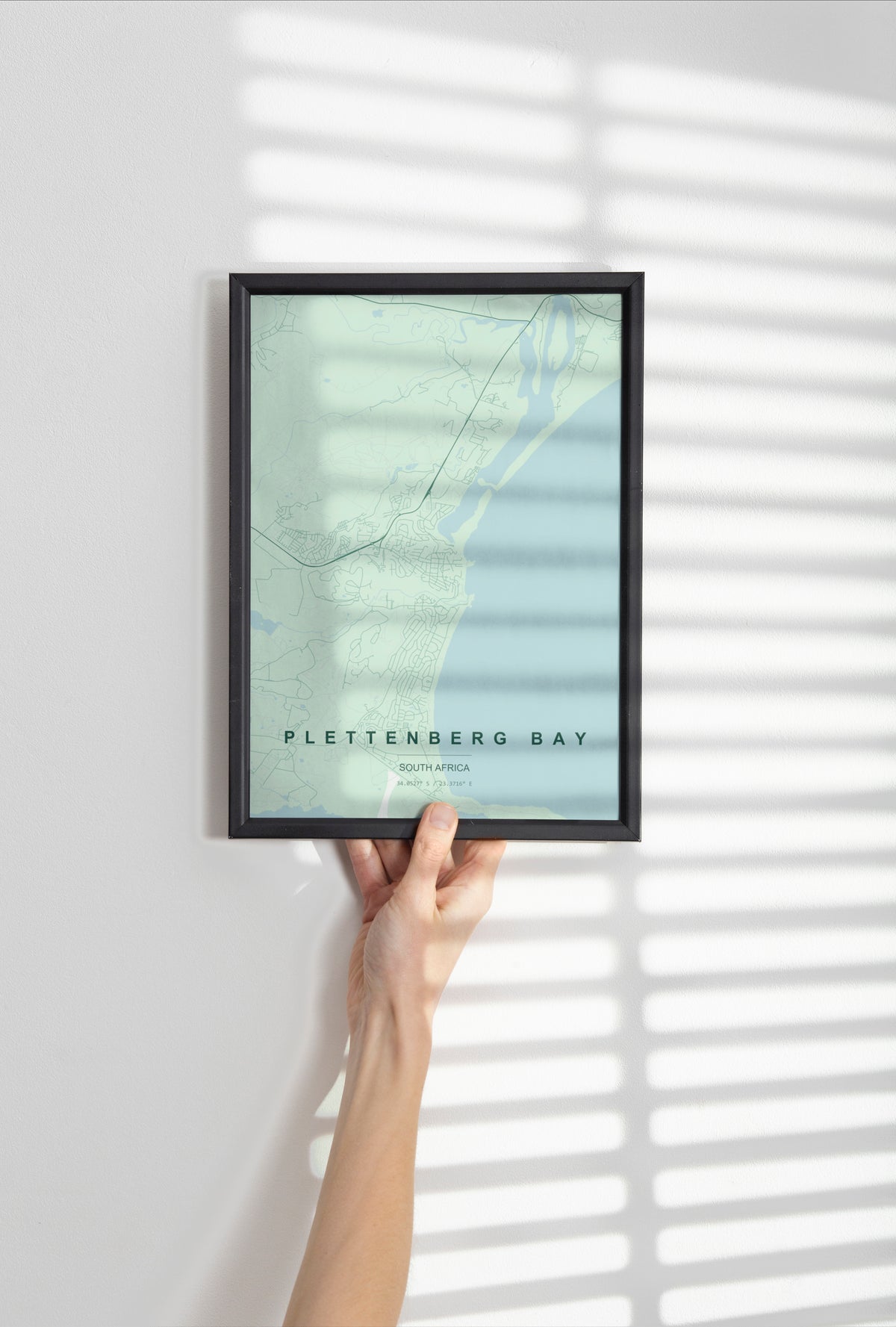 Plettenberg Bay, Western Cape, South Africa map print in the Forest theme in a black frame held against a pale wall