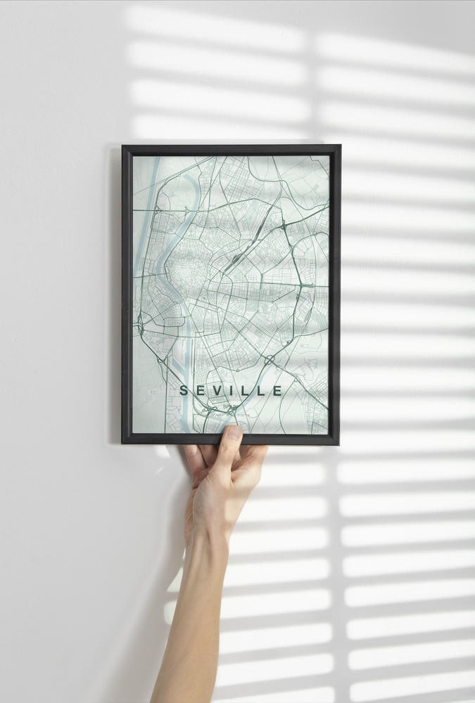 Seville map print in the Forest theme in a black frame held against a pale wall