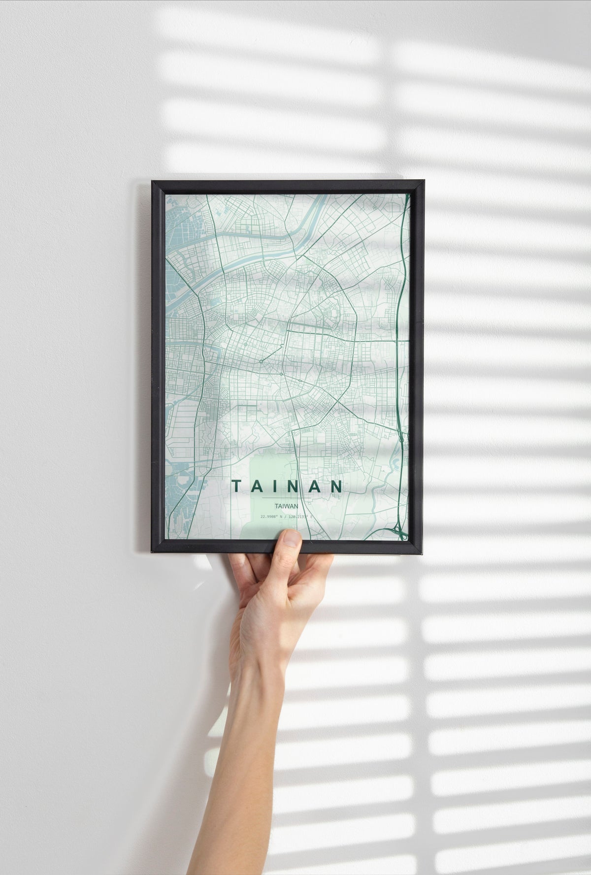 Tainan, Taiwan map print in the Forest theme in a black frame held against a pale wall